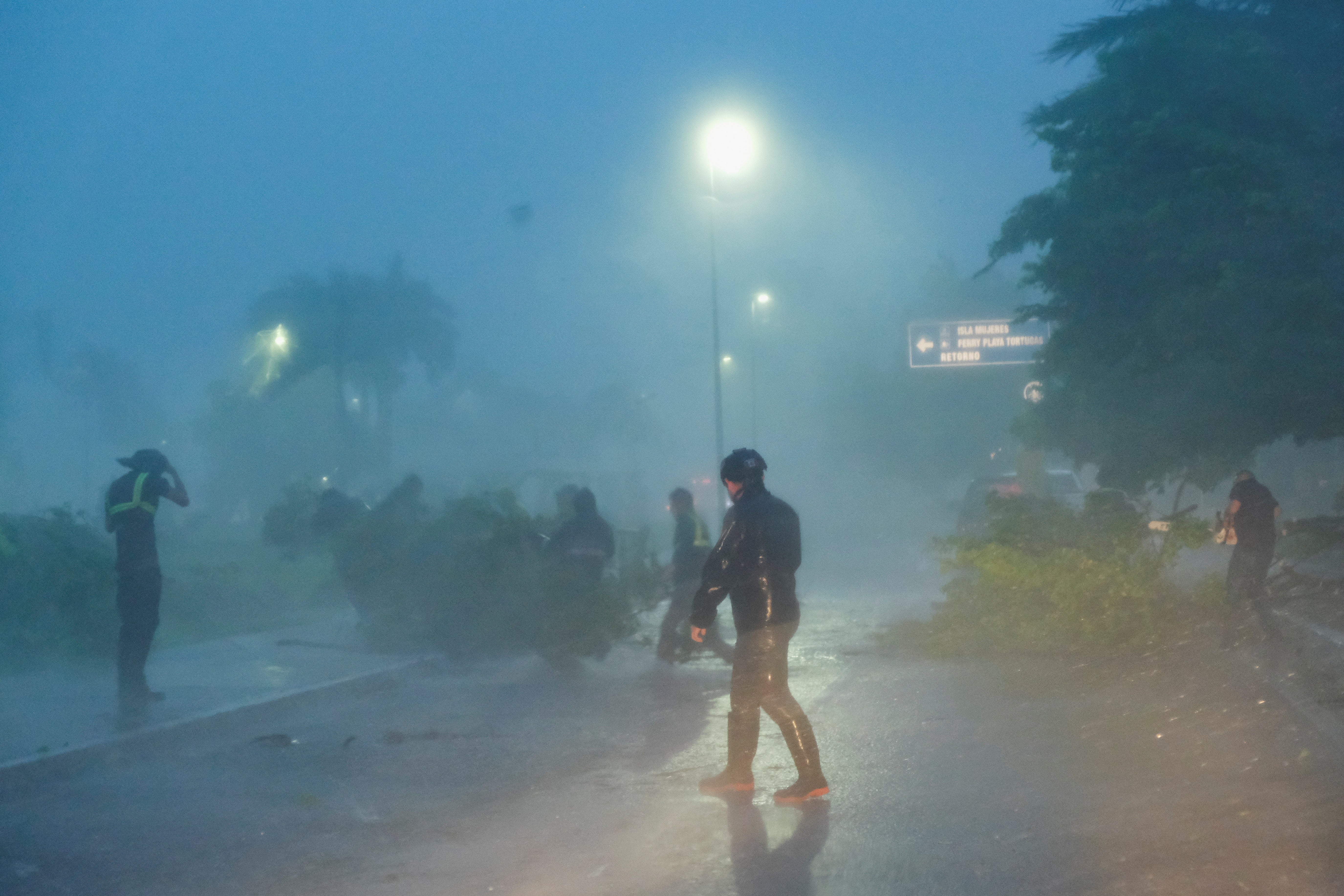 Authorities remove tree branches toppled by heavy winds and rain in Cancún, Mexico caused by Helene. The storm upgraded to a hurricane on Wednesday morning