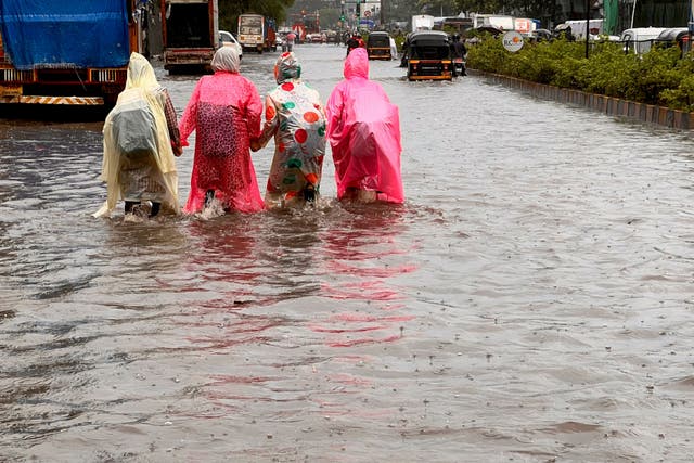 <p>File. Schoolchildren wade through a waterlogged road after heavy monsoon rainfall in Mumbai, India, on 21 July 2023 </p>