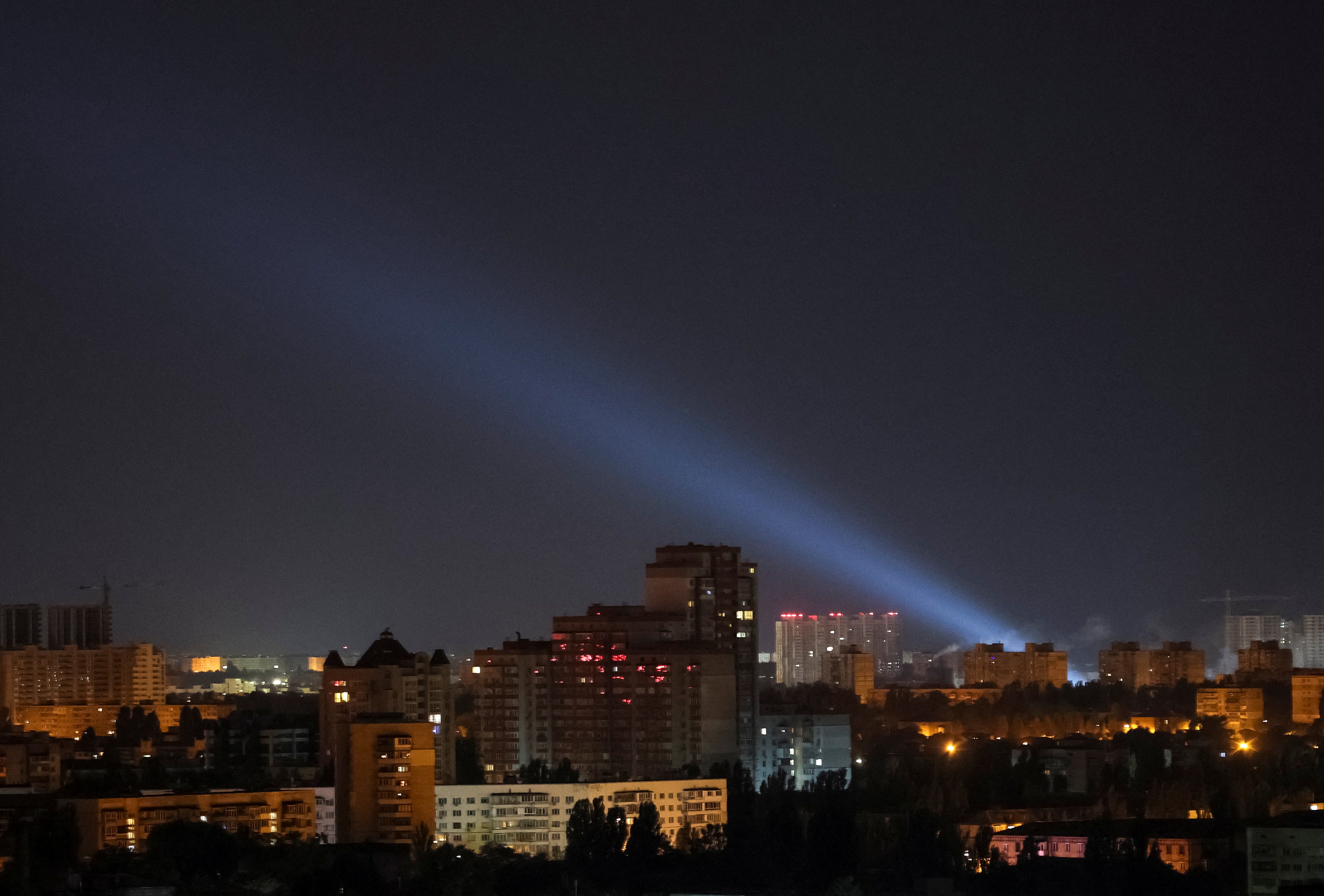 Ukrainian service personnel use searchlights as they search for drones in the sky over the city centre in Kyiv