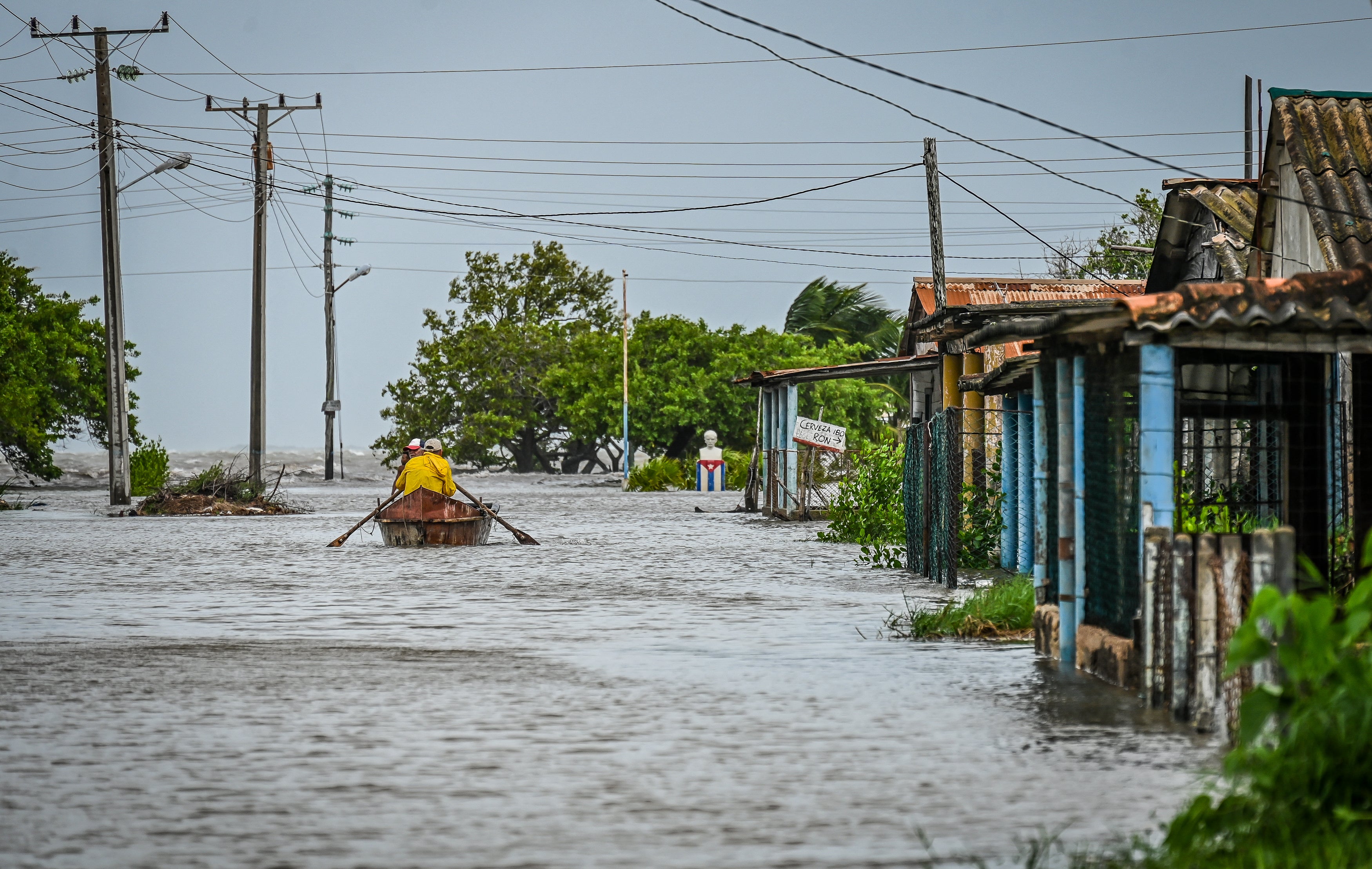 After the passage of Hurricane Helene in Guanimar, Cuba, a man sails on a boat to safe zones in a flooded street