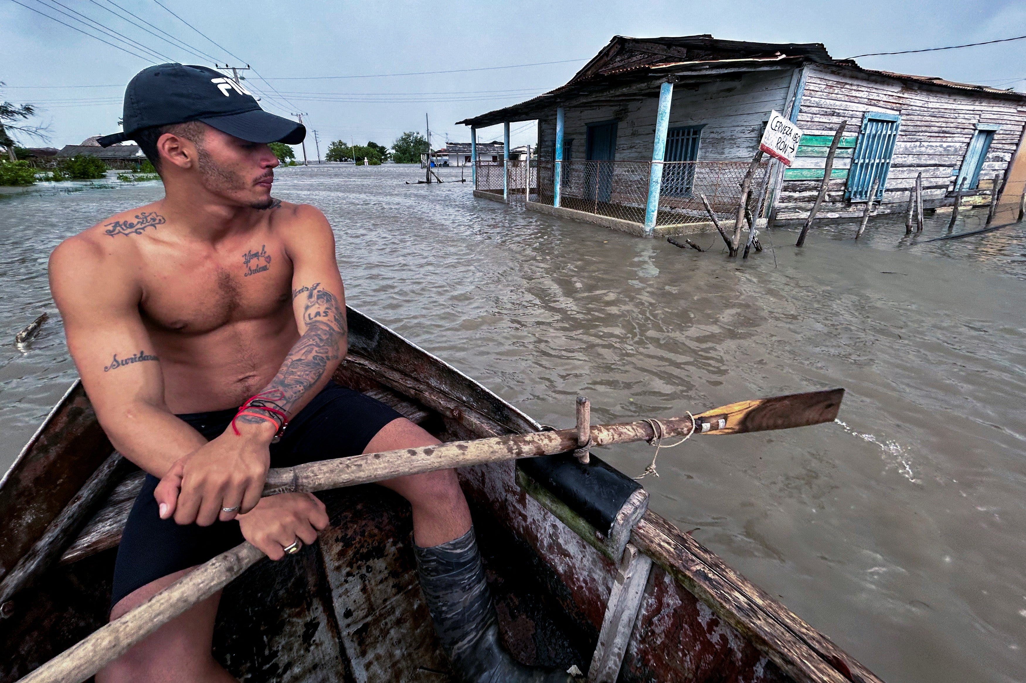 Man sails on a boat through a flooded street after Hurricane Helene passed through Guanimar, Cuba