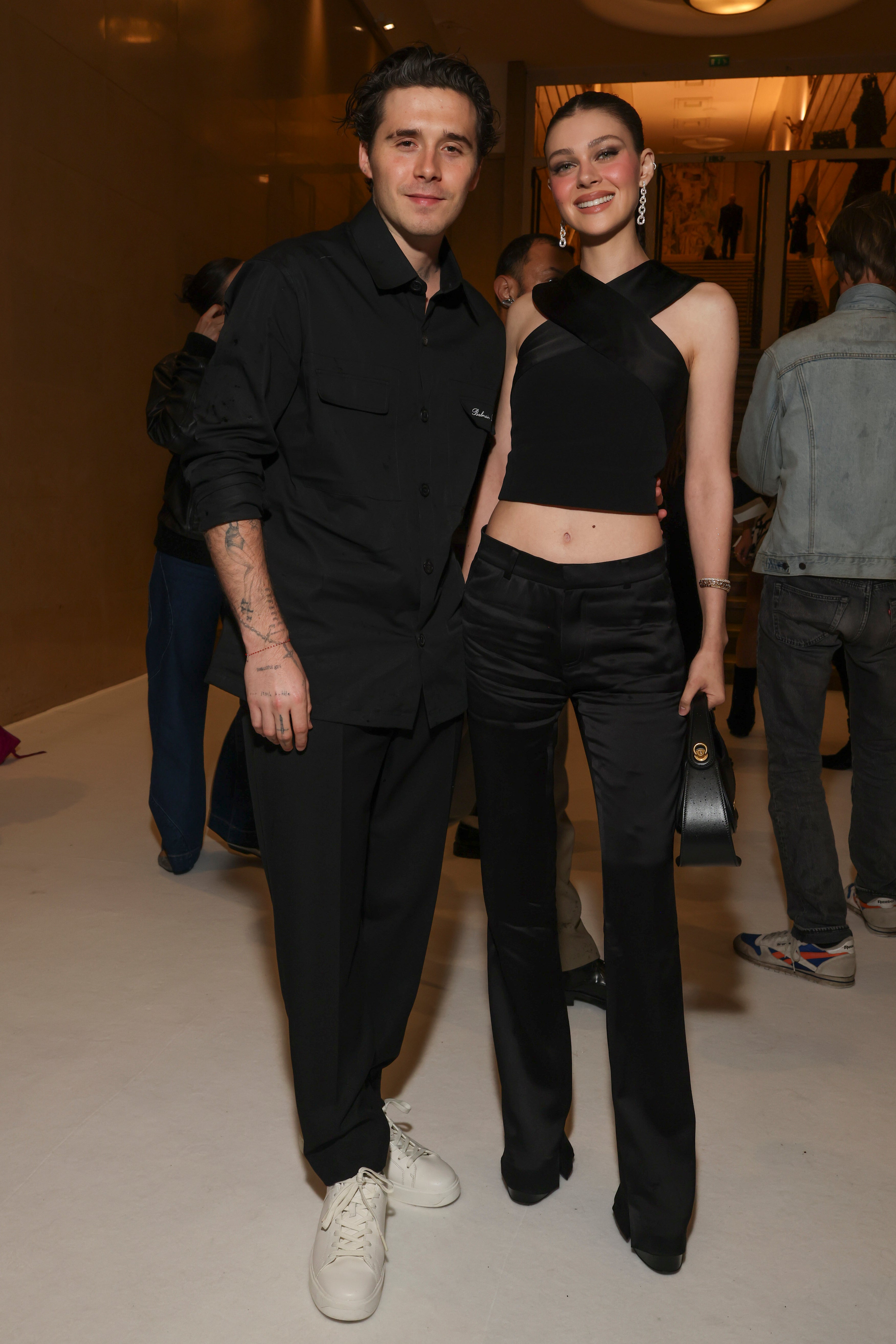 <p>Brooklyn Beckham and Nicola Peltz kept it simple in black satin (Vianney Le Caer/AP)</p>