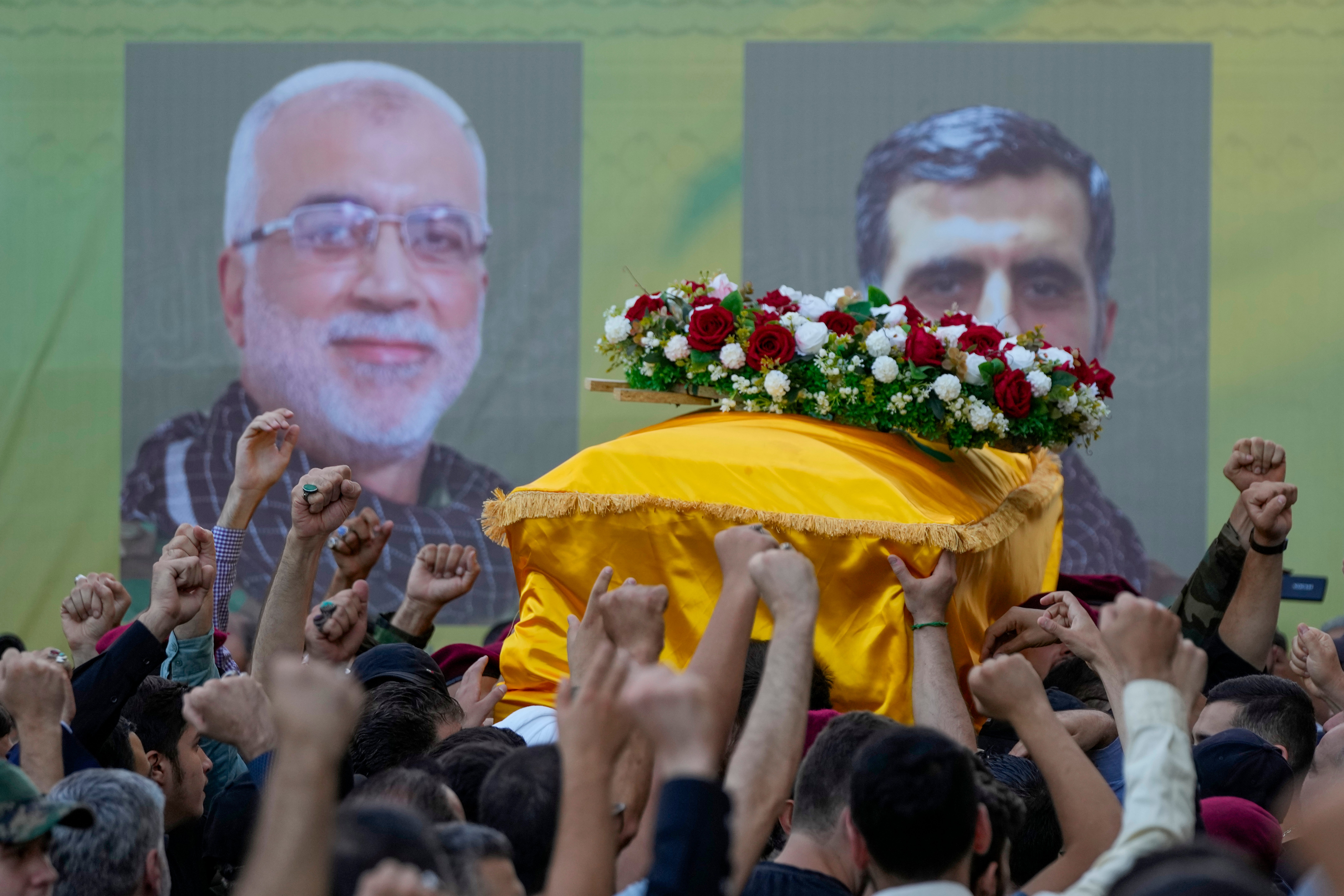 Hezbollah members carry the coffins of Hezbollah commanders Ibrahim Kobeisi, and Hussein Ezzedine, during their funeral procession in Beirut, Wednesday, September 25