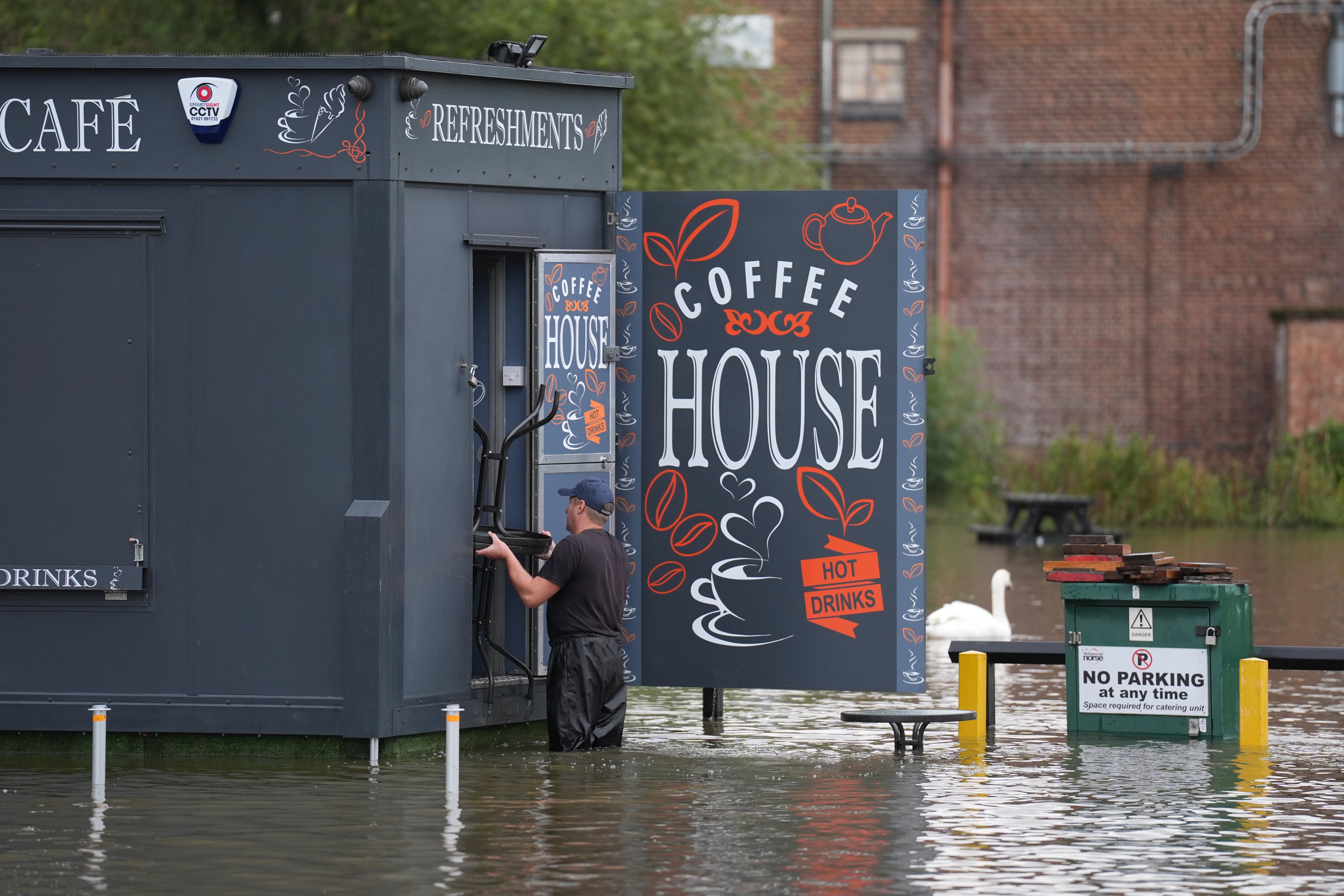 A man moves furniture out of flood water in Wellingborough