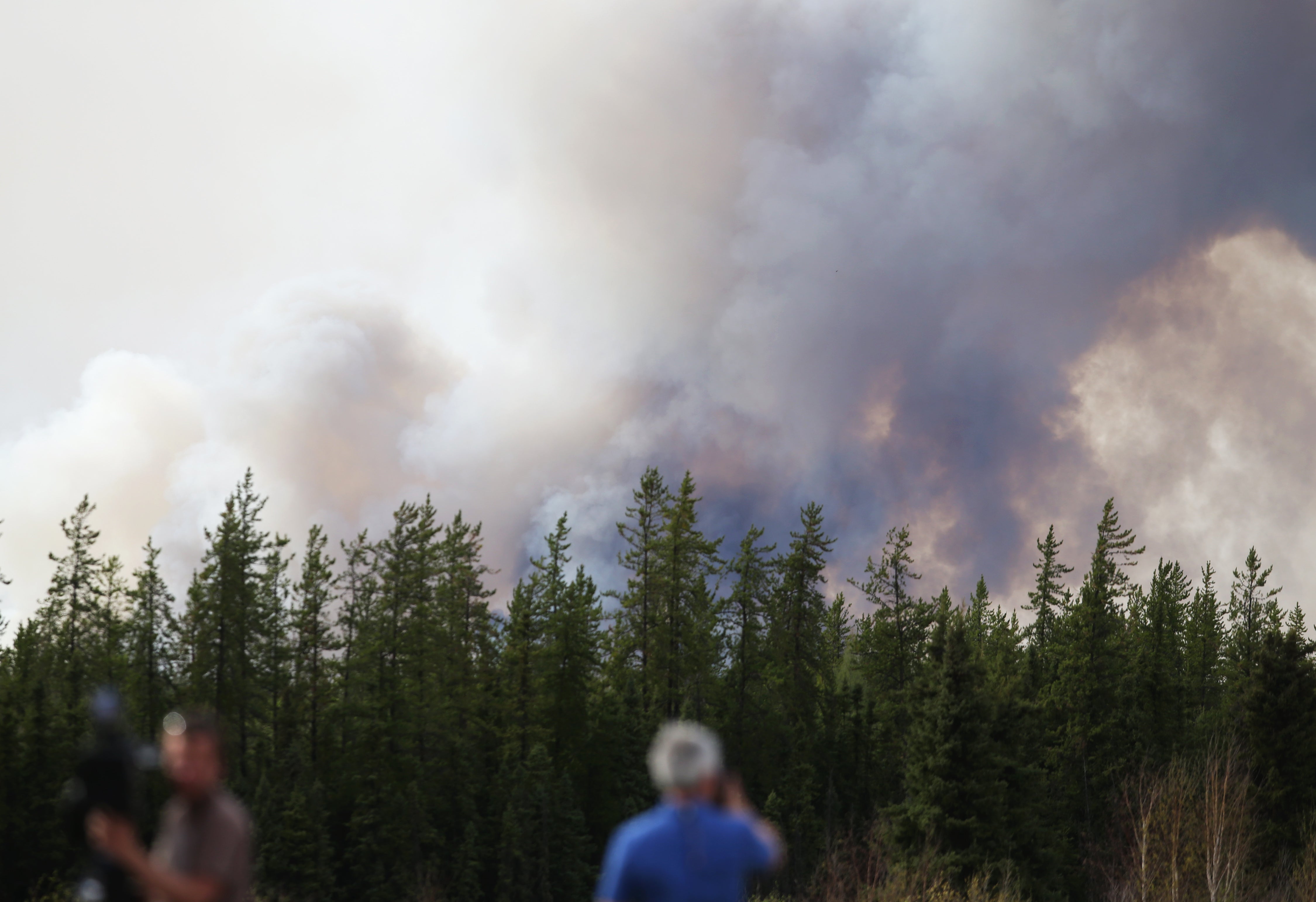 Smoke rises outside Fort McMurray in May 2016, as forest fires forced tens of thousands from their homes. Heat radiating from the fire caused structures to burst into flame