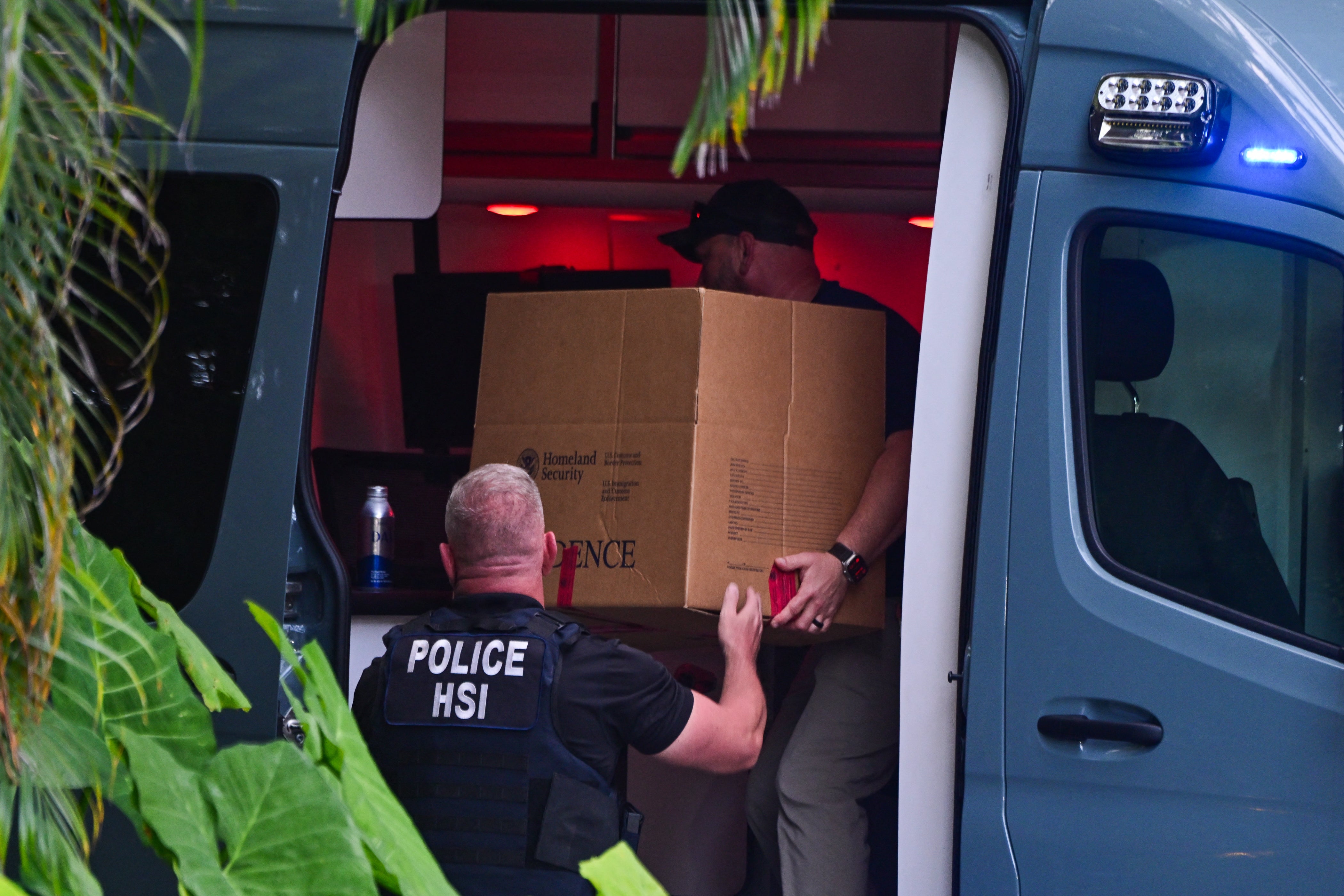 Investigation agents load a box into a car at the entrance of US producer and musician Sean “Diddy” Combs’s Miami Beach home