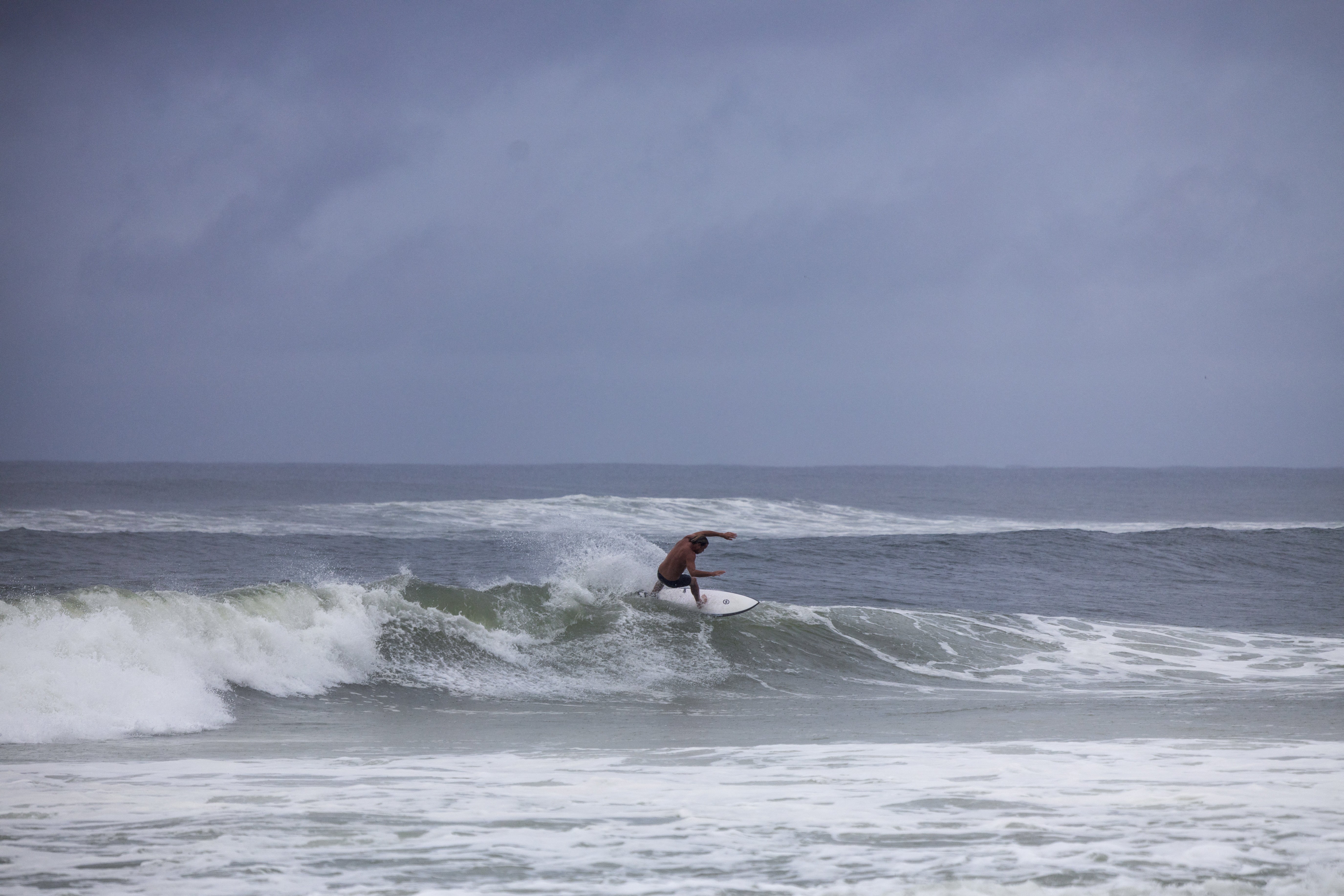 A surfer at Florida’s Panama City Beach makes use of the waves ahead of Hurricane Helene