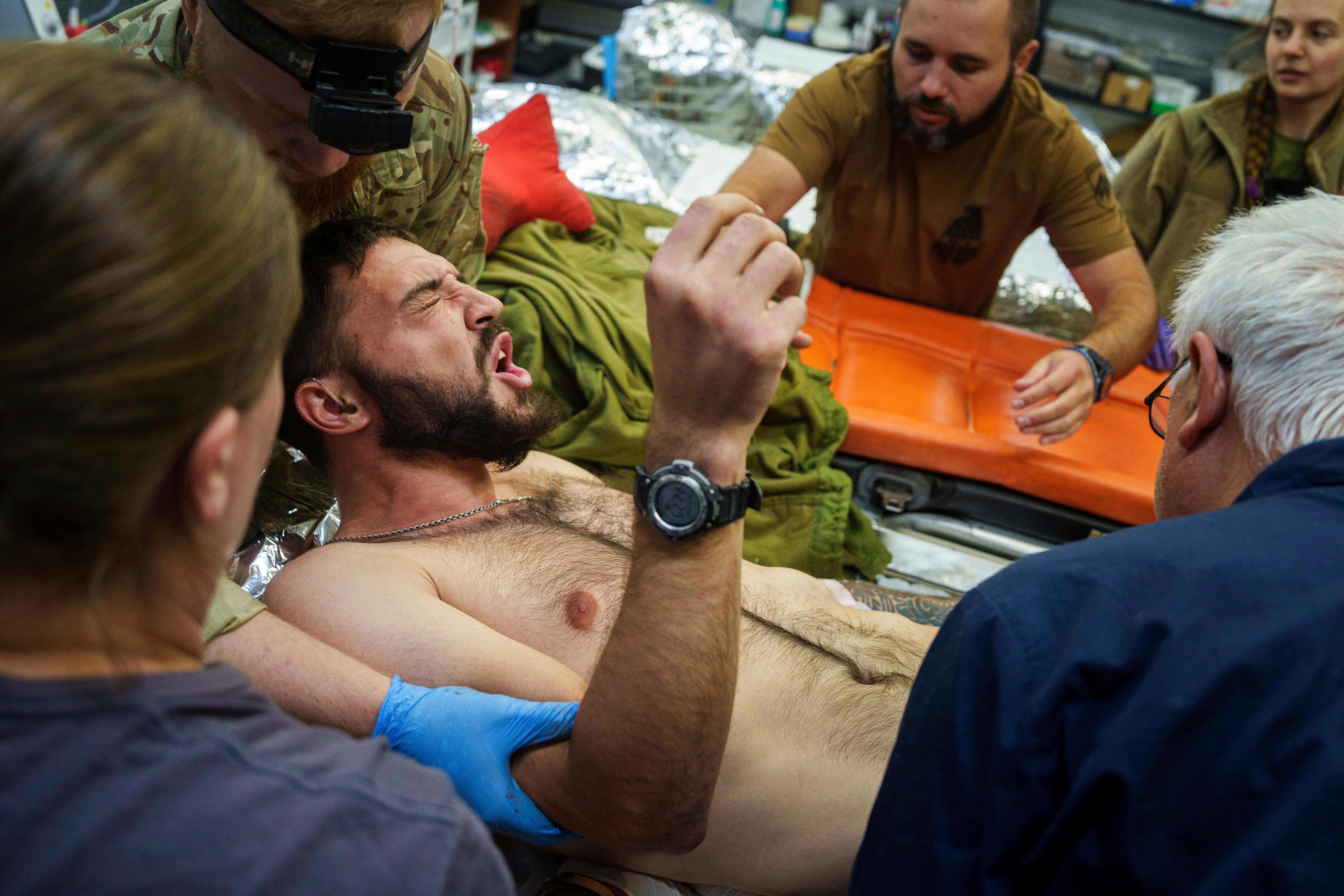 Ukrainian military medics of the Azov brigade move an injured comrade on a stretcher, at the stabilization point near Toretsk, Donetsk region, Ukraine