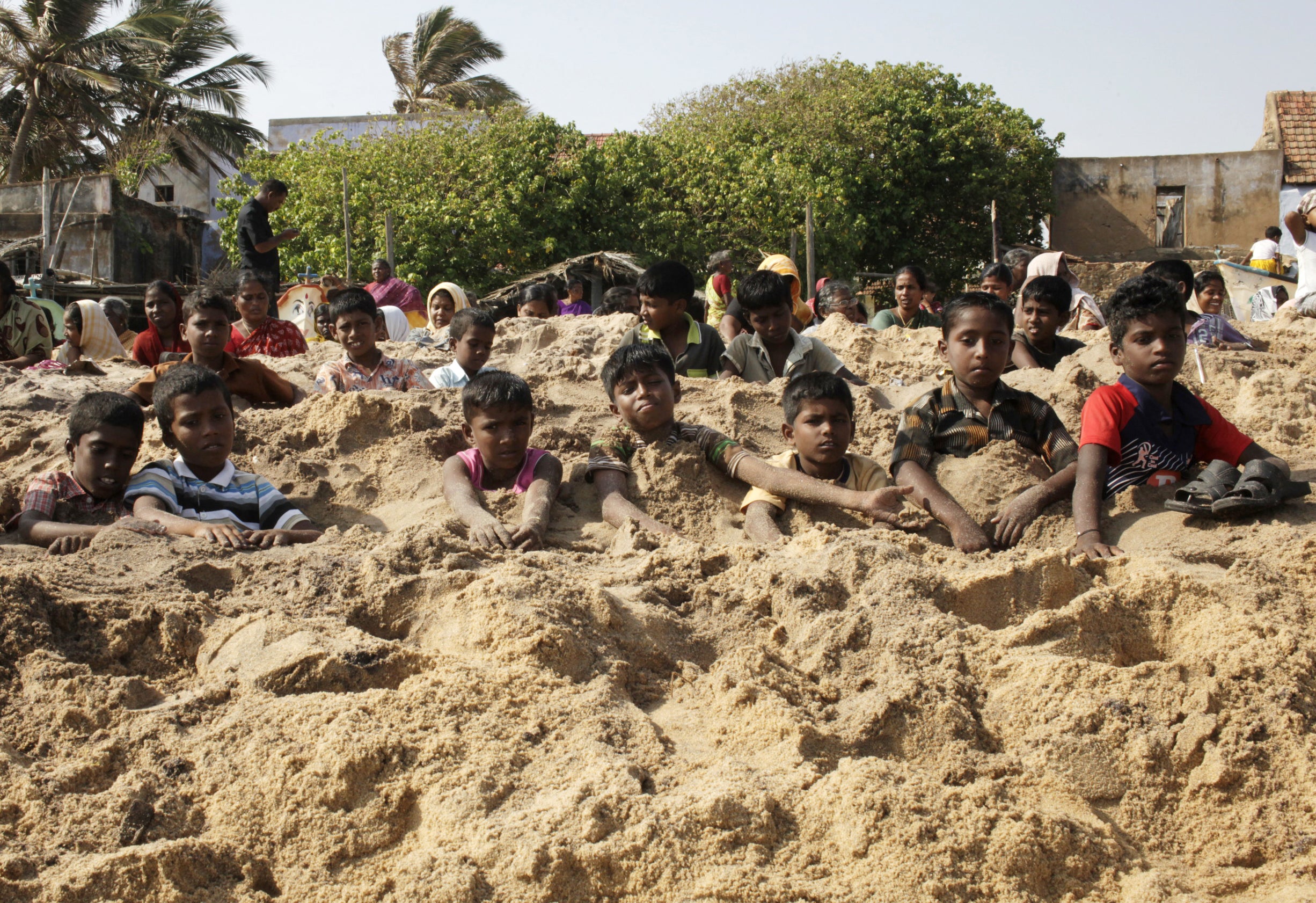 Indian activists bury themselves in sand as part of a protest against the Kudankulam Nuclear Power Project on 26 September 2012