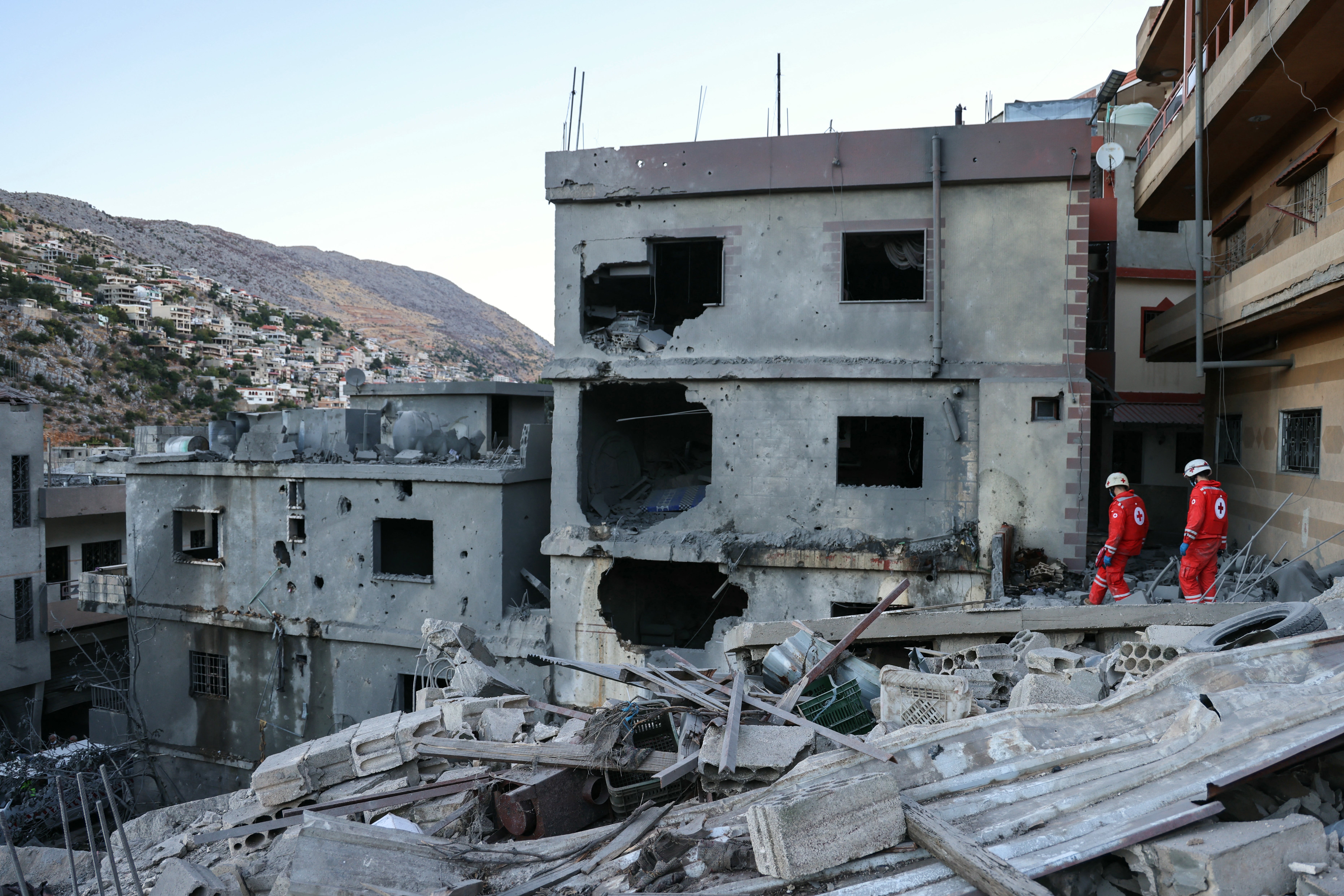 Rescuers check the destruction following an overnight Israeli airstrike in a southern Lebanese village