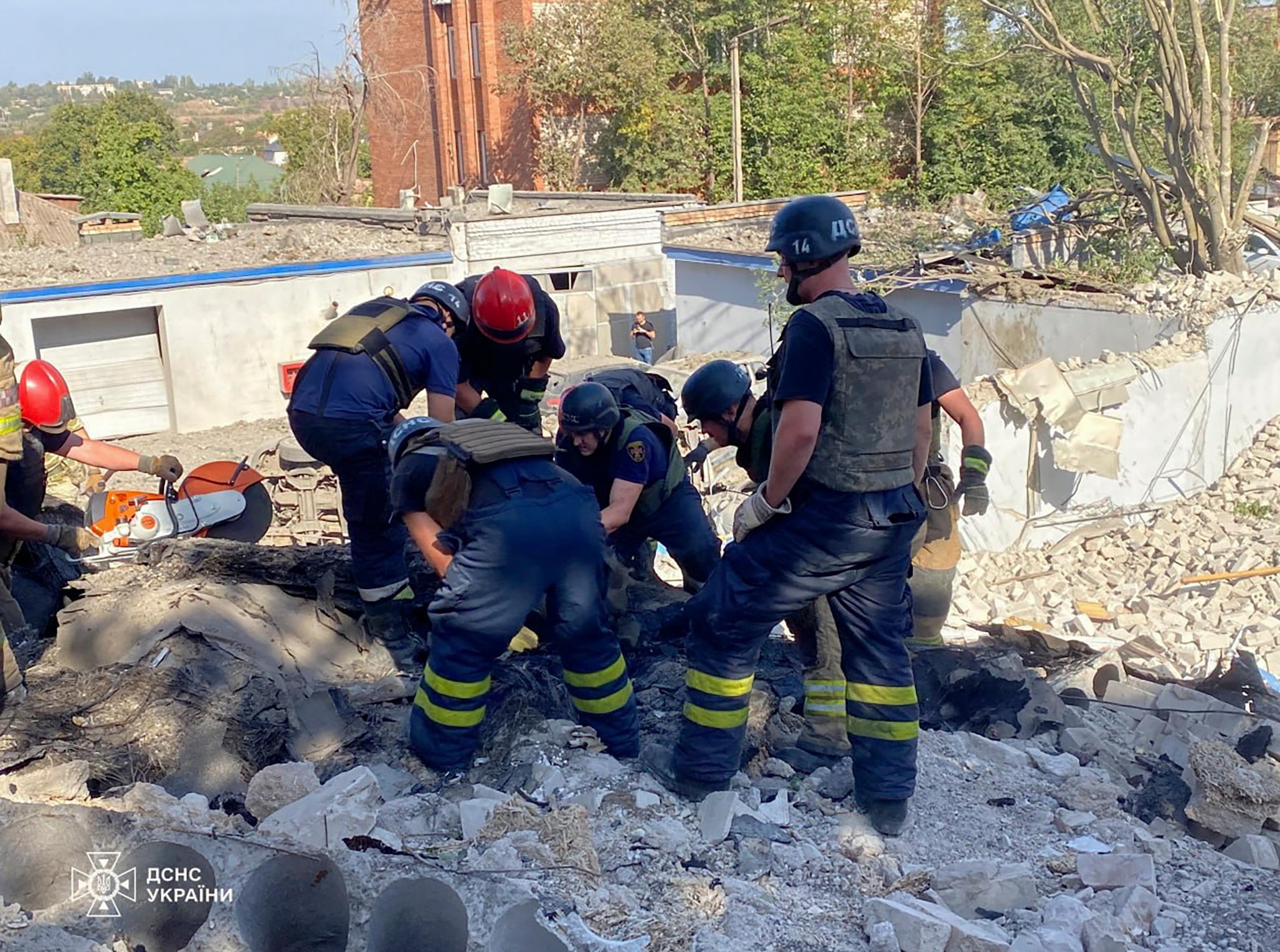 A handout photo made available by the State Emergency Service shows Ukrainian rescuers work at the site of National Police headquarters following a shelling in Kryvyi Rih