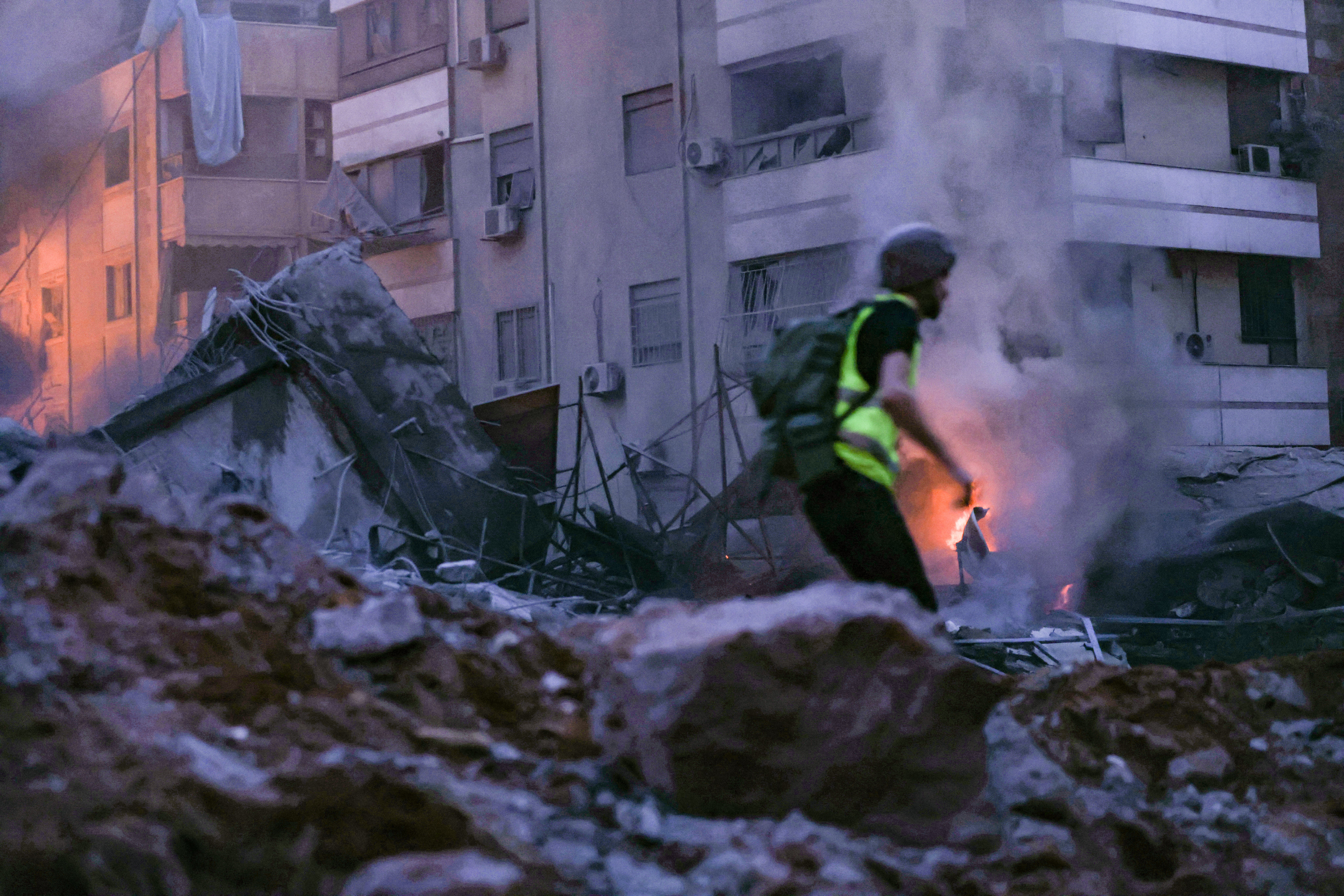 A rescue worker runs amid the rubble