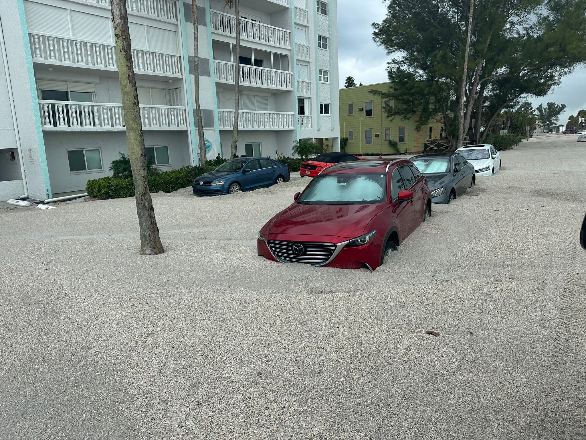 Geparkeerde auto's omringd door zand opgepikt door de orkaan Helen in Pinellas County, Florida