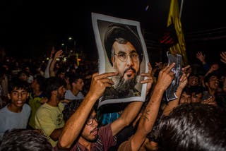 Kashmiri Shiite Muslims holding the picture of Hassan Nasrallah as they try to march, chanting anti-Israel and anti-US slogans