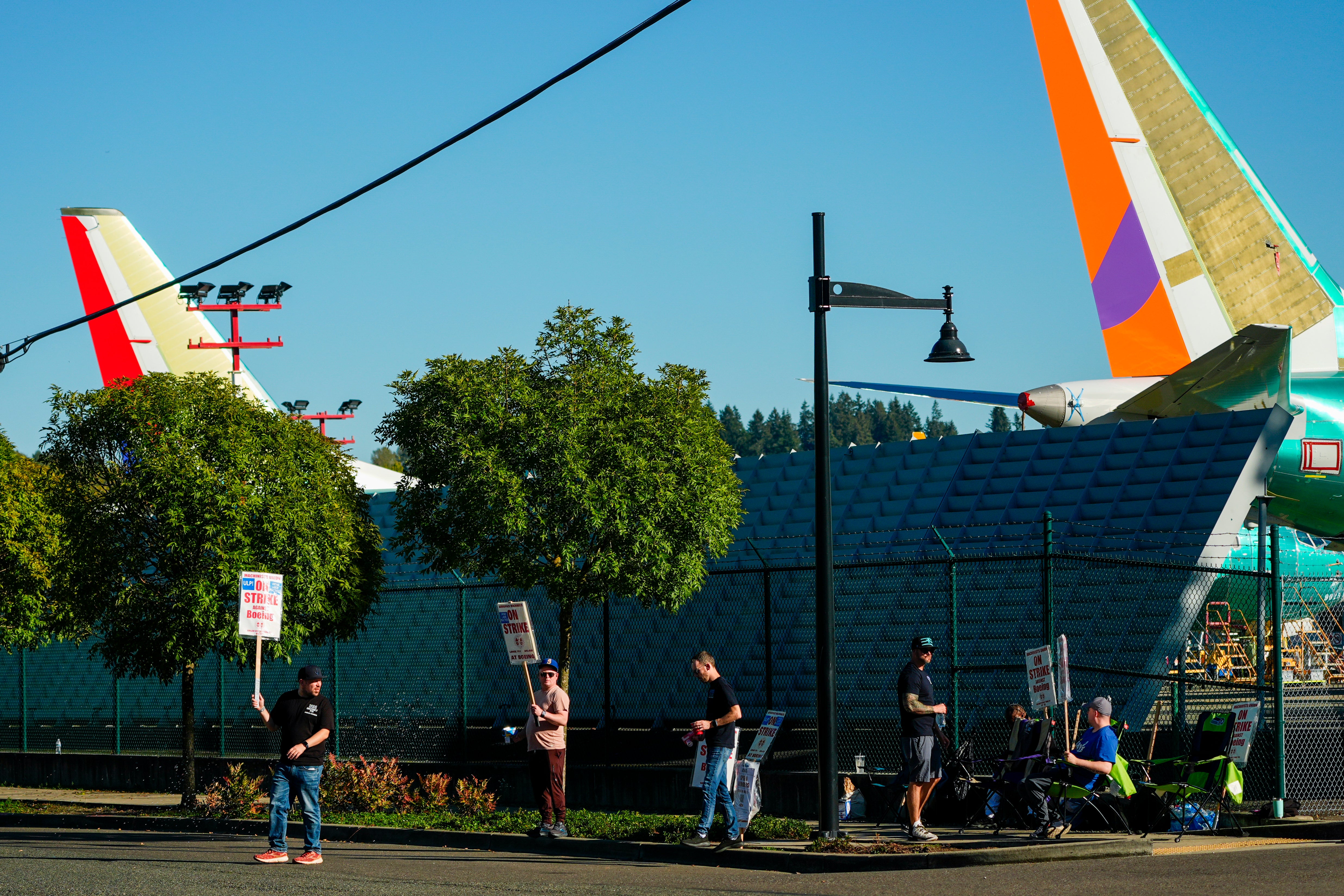 Boeing 737 Max aircrafts are seen behind fences as Boeing employees work the picket line while strikin