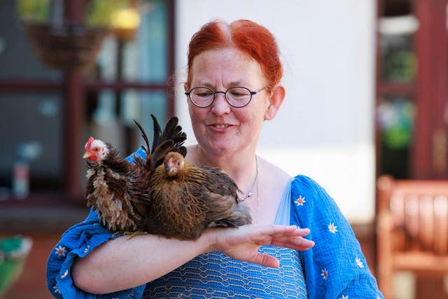 Catherine Hoy holding two hens during a pet therapy session at Seapatrick Care Home, Banbridge (Liam McBurney/PA)