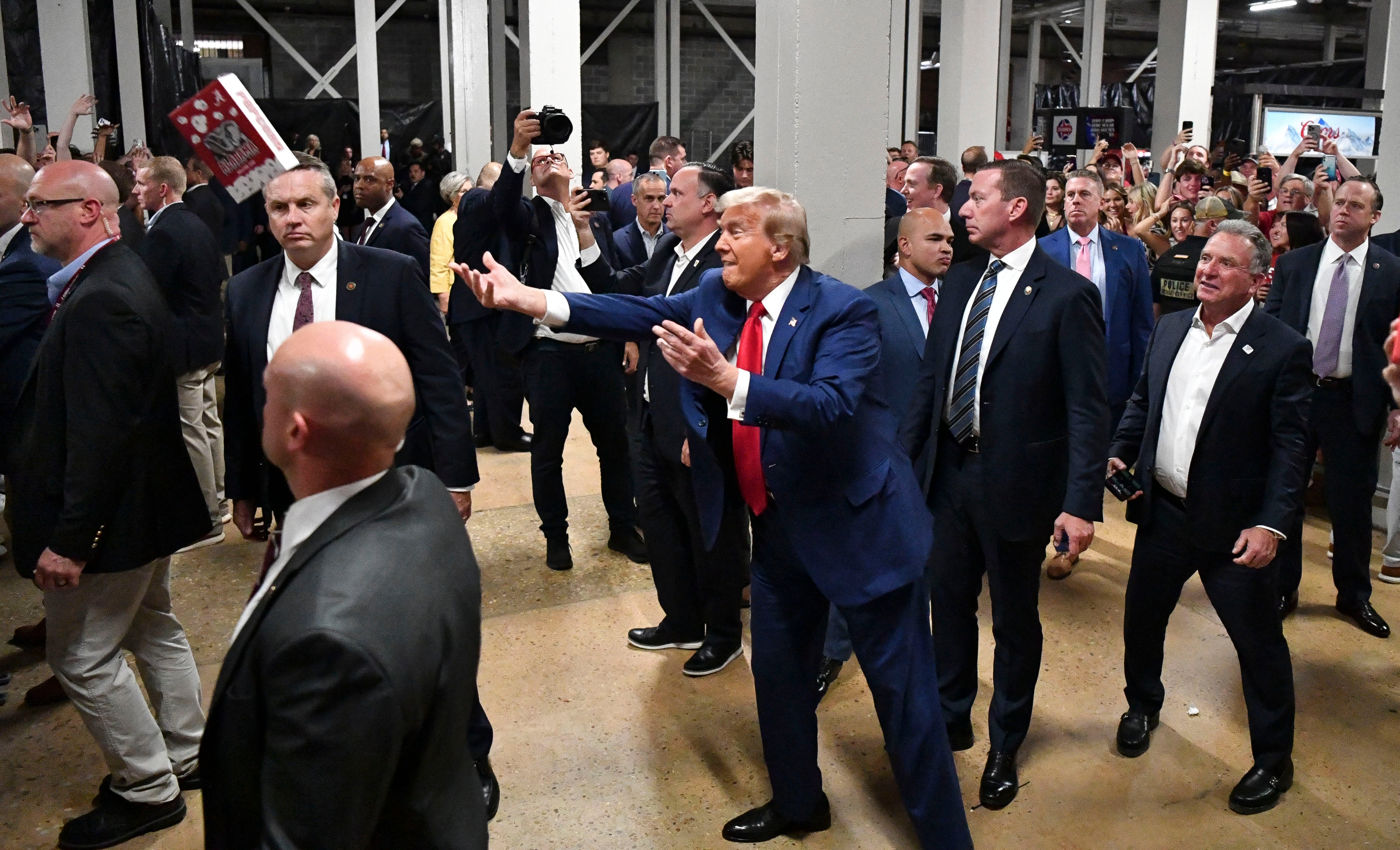 Donald Trump tosses boxes of popcorn to fans at Bryant-Denny Stadium before a football game between the Alabama Crimson Tide and the Georgia Bulldogs