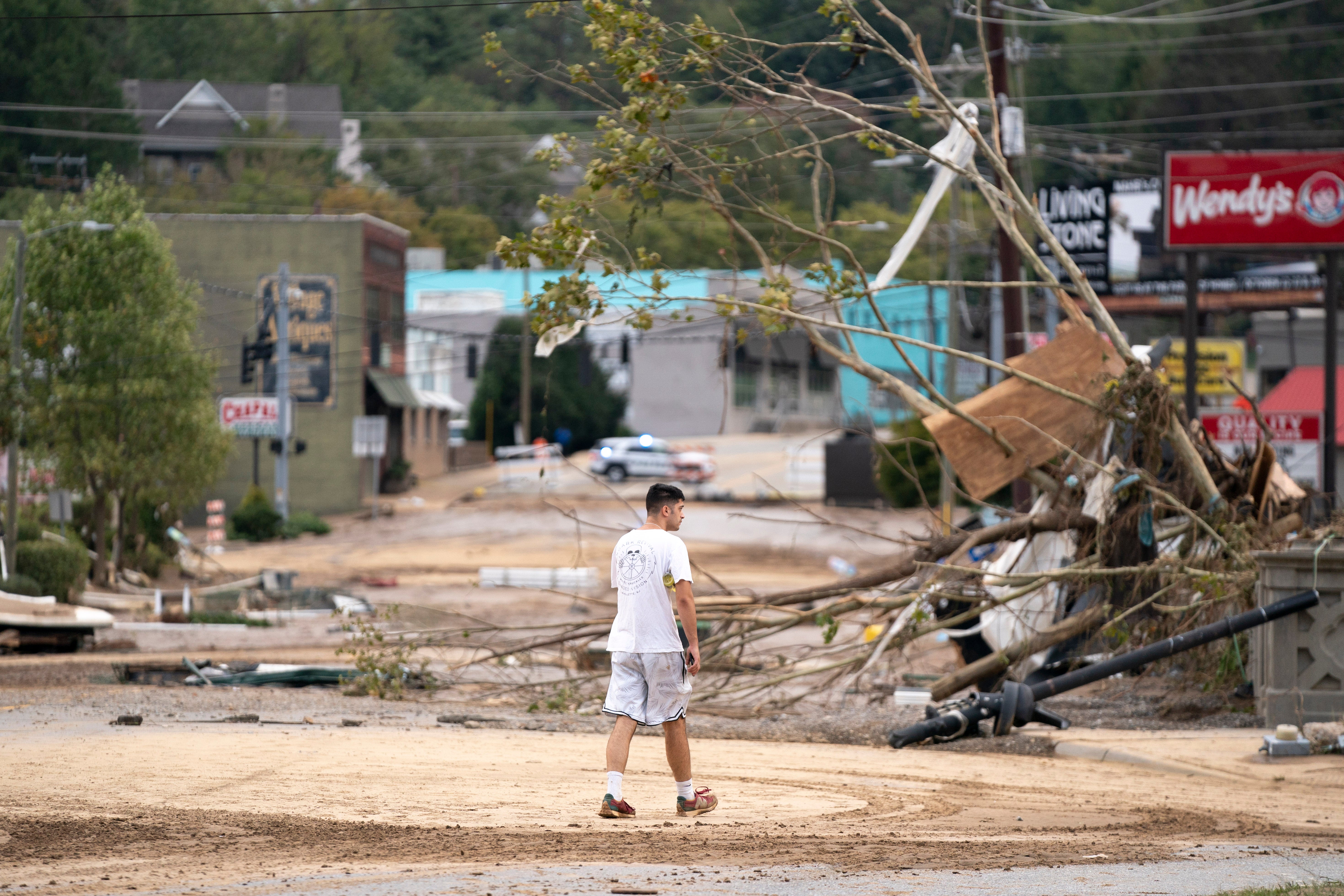 Noah Levinson looks at storm damage near the Biltmore Village in the aftermath of Hurricane Helene on September 28, 2024 in Asheville, North Carolina