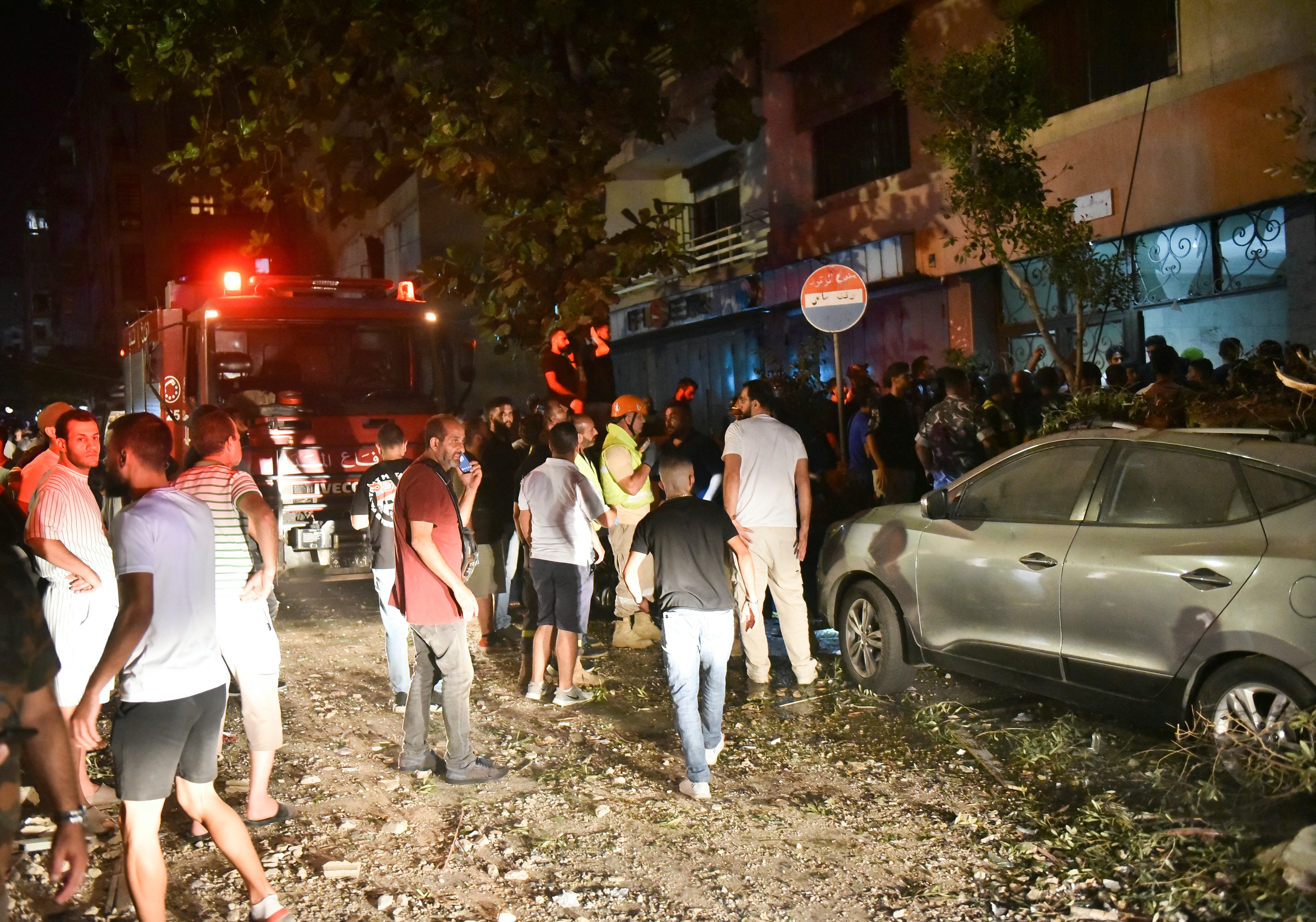 People gather outside an apartment building hit by an Israeli air strike in Beirut's Cola district, September 30, 2024. Two people were killed in an Israeli strike on Beirut on September 30, a Lebanese security source said, the first strike on the city itself since the October 7 Hamas attack on Israel last year. An Israeli drone targeted an apartment belonging to two members of the Lebanese Islamist group Jamaa Islamiya, said the source