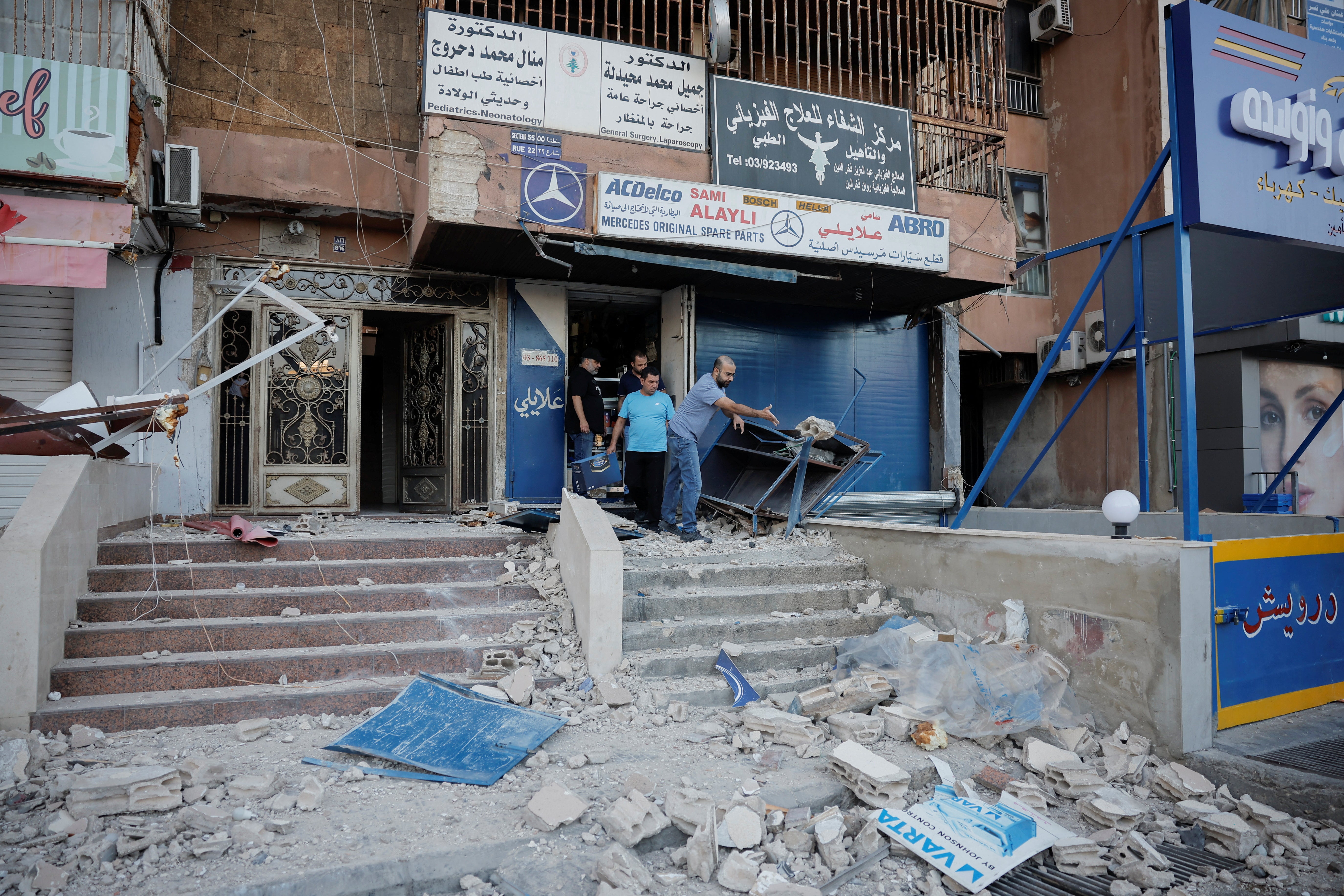 People clear debris from shops damaged in an Israeli strike, amid ongoing cross-border hostilities between Hezbollah and Israeli forces, in Kola, central Beirut, Lebanon September 30, 2024