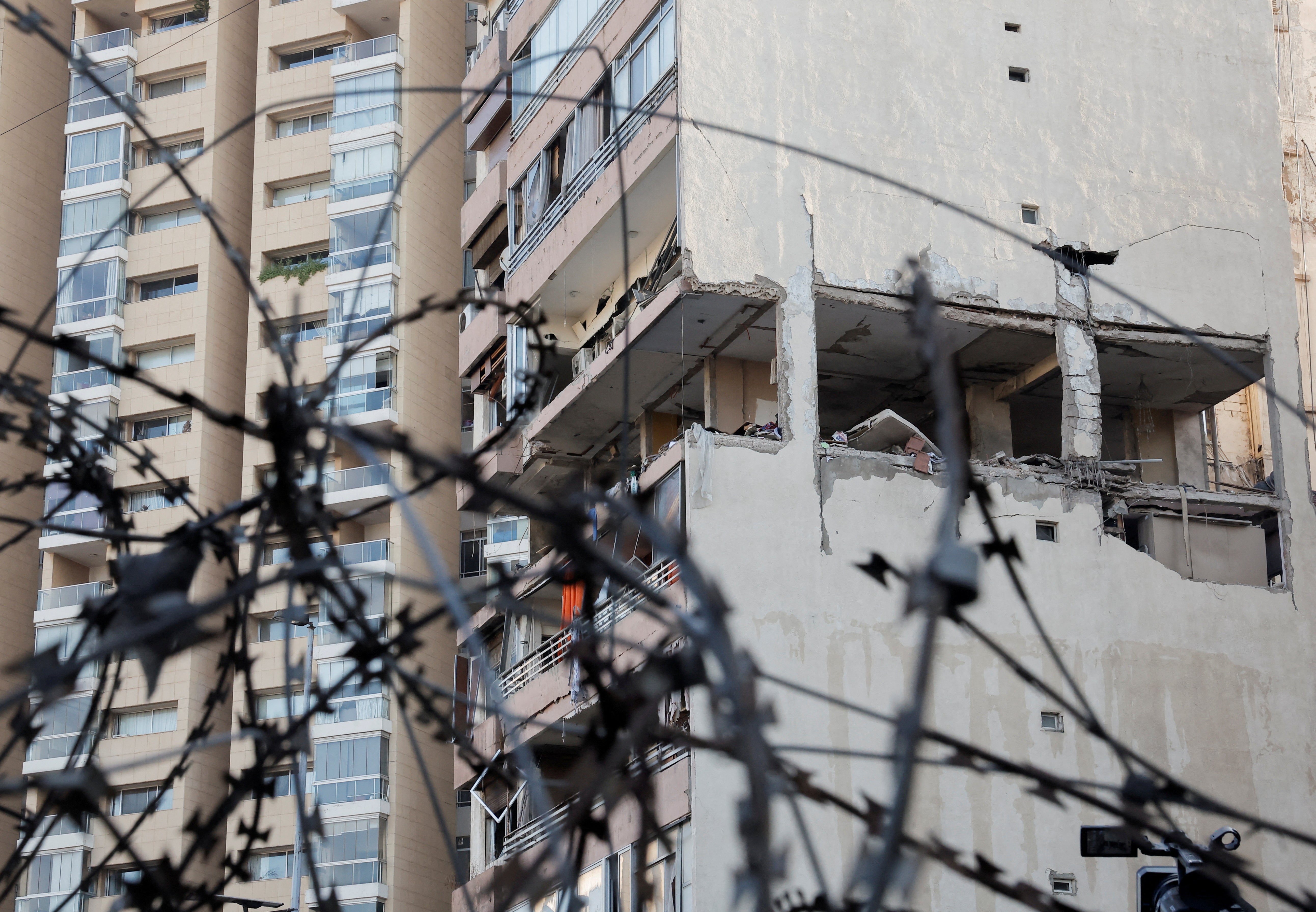 A building damaged in an Israeli strike is seen through a razor wire fence, amid ongoing cross-border hostilities between Hezbollah and Israeli forces, in Kola, central Beirut, Lebanon September 30, 2024