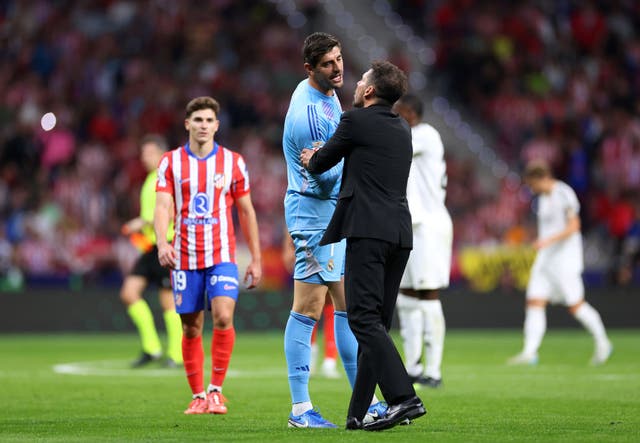 <p>Diego Simeone speaks with Thibaut Courtois during the Madrid derby</p>