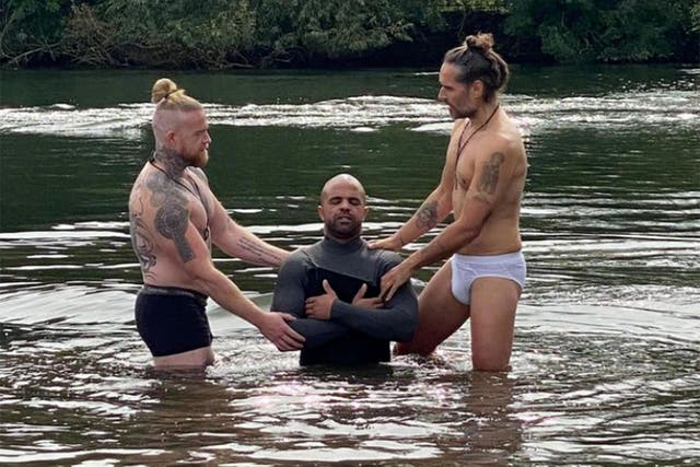 <p>Russell Brand Brand posted the photos if him conducting a baptism in a lake wearing nothing but a pair of pants</p>