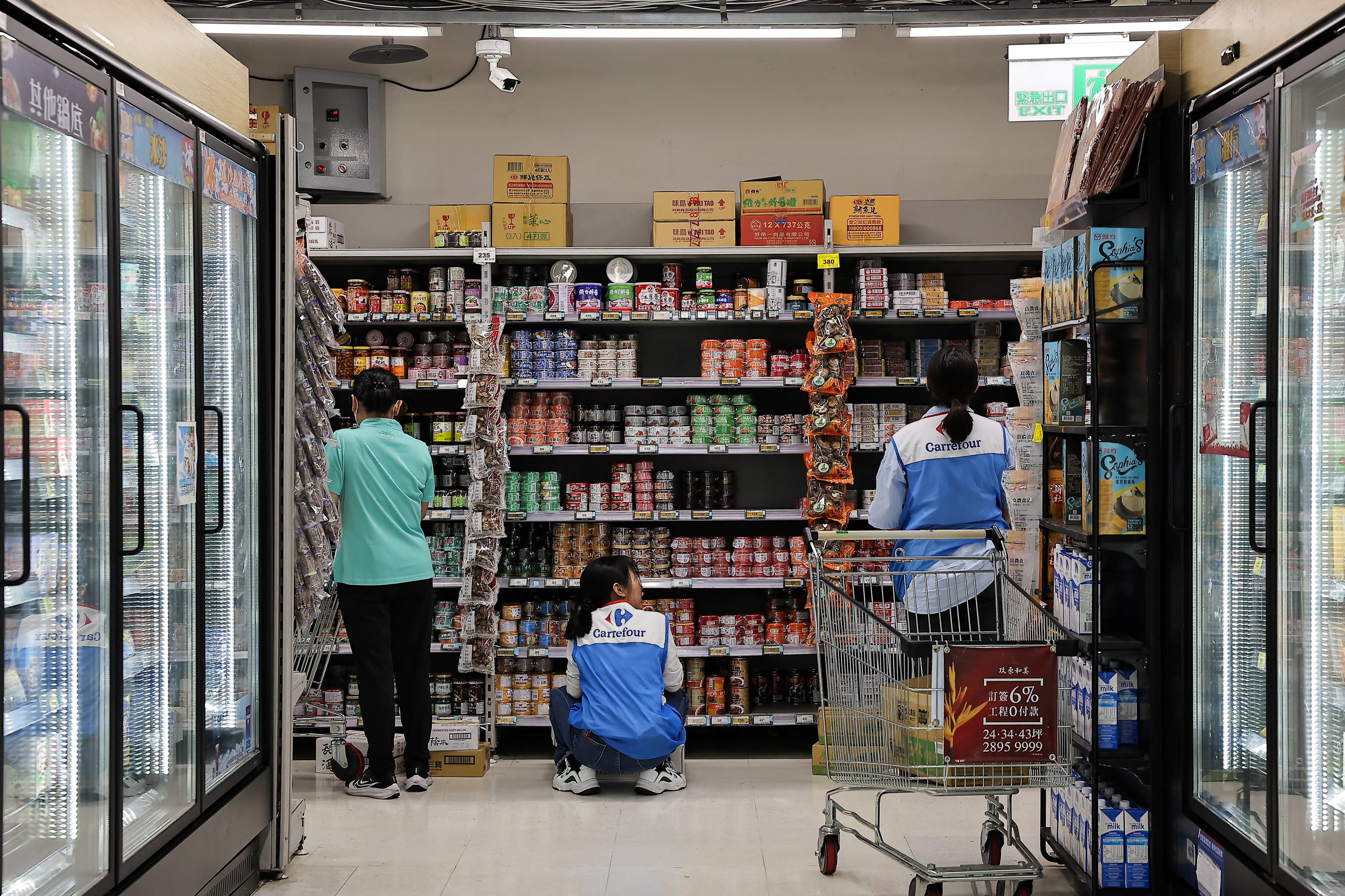 Employees in a supermarket store canned goods ahead of Typhoon Krathon, which is expected to worsen