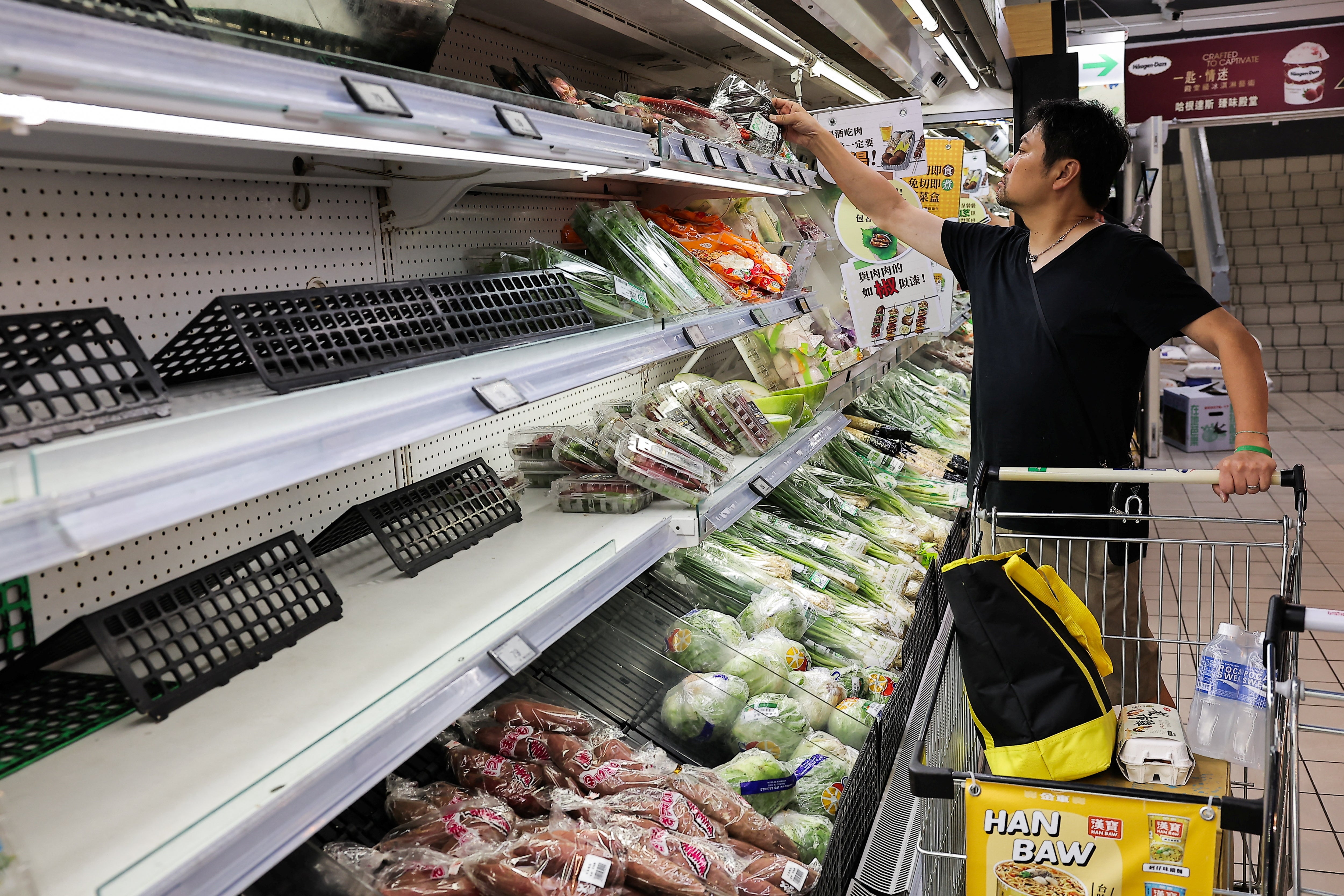 People buy food at a supermarket as Typhoon Krathon which is expected to intensify and make an unusual landfall