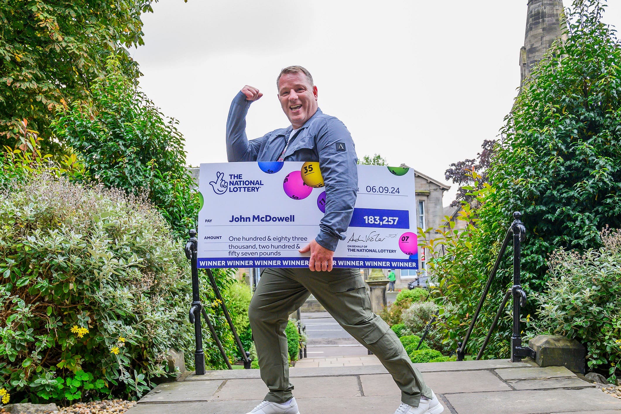 John McDowell celebrates his EuroMillions win with the customary big cheque (Alan Peebles/PA Wire)