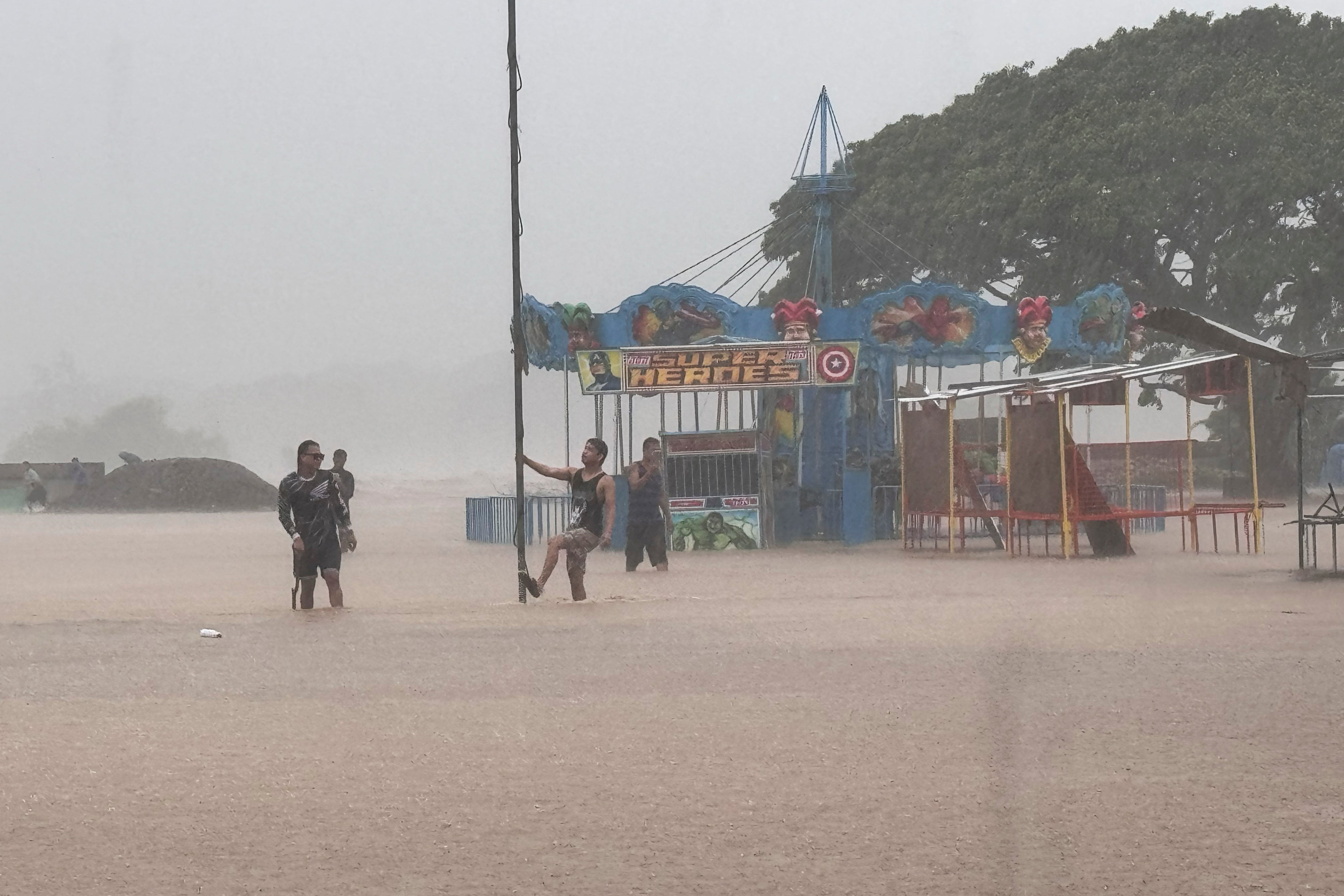 Residents negotiate floods caused by powerful Typhoon Krathon locally called ‘Typhoon Julian’ at Bacarra, Ilocos Norte province, northern Philippines