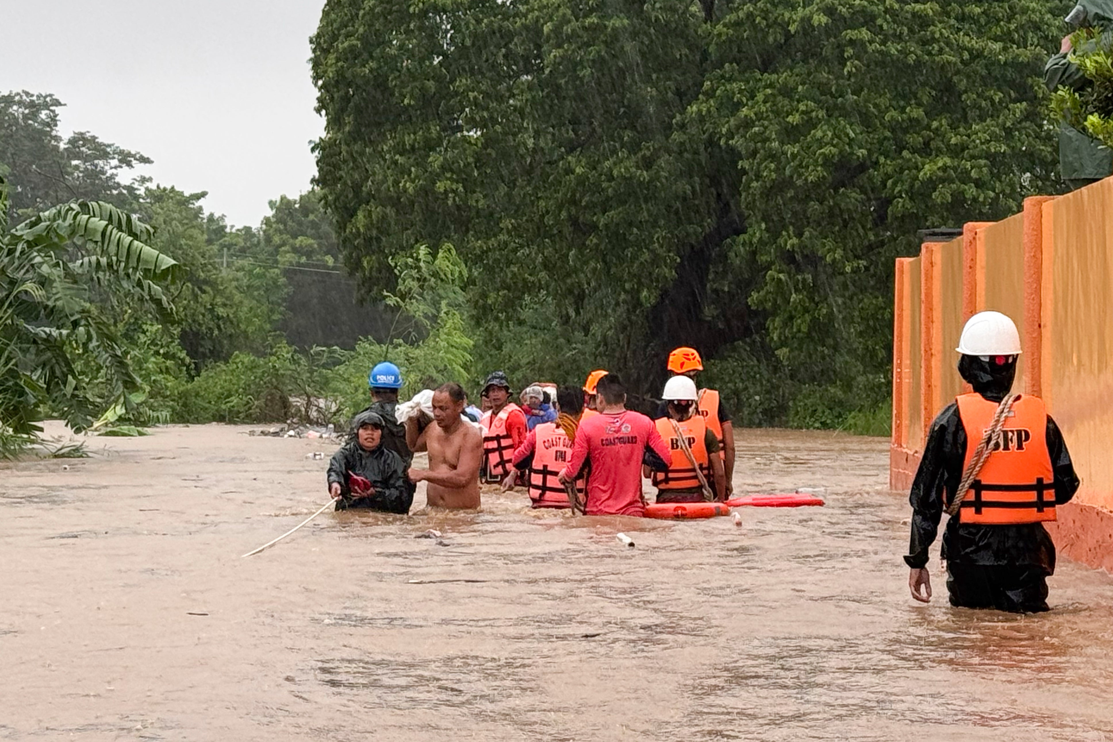 Rescuers help residents as they negotiate floods caused by powerful Typhoon Krathon locally called ‘Typhoon Julian’ at Bacarra, Ilocos Norte province, northern Philippines