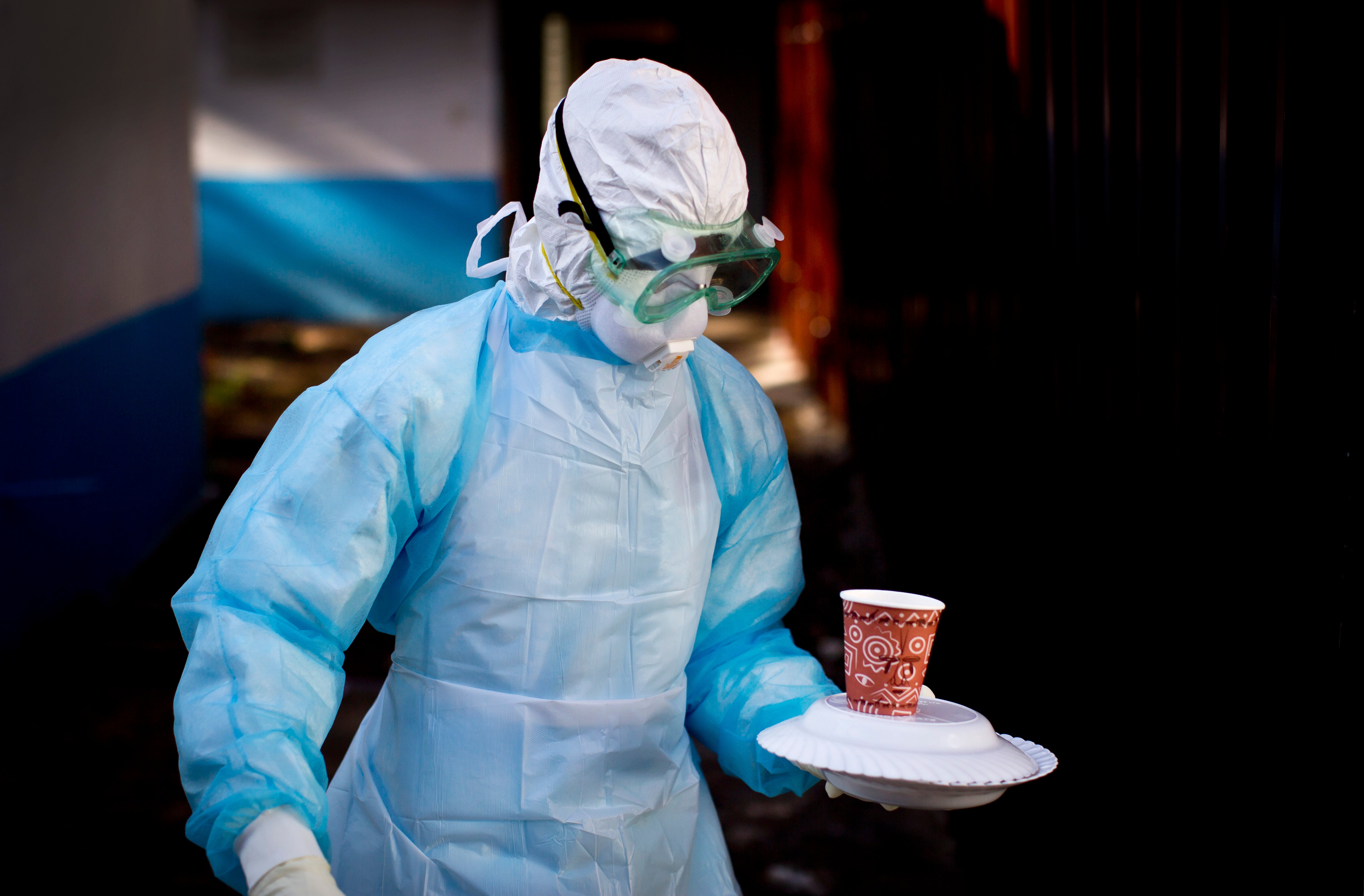 A medical worker from the Infection Prevention and Control Department, wearing full protective gear, carries a meal to an isolation tent housing a man being quarantined after being diagnosed with a Marburg virus carrier in Uganda at the Kenyatta National Hospital in Nairobi , Kenya, came into contact in 2014