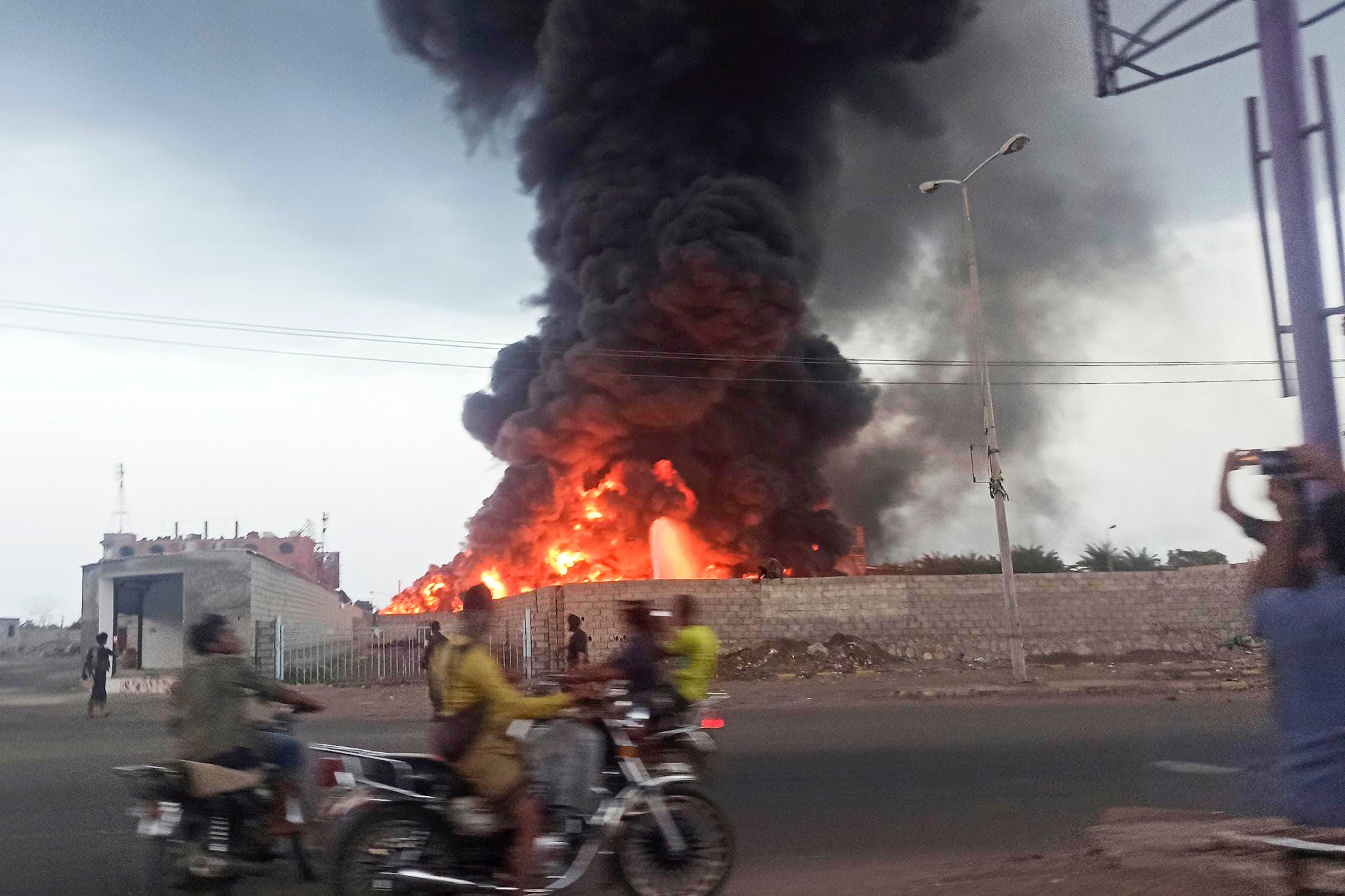 A large fire and plume of smoke is visible in the port city of Hodeida, Yemen