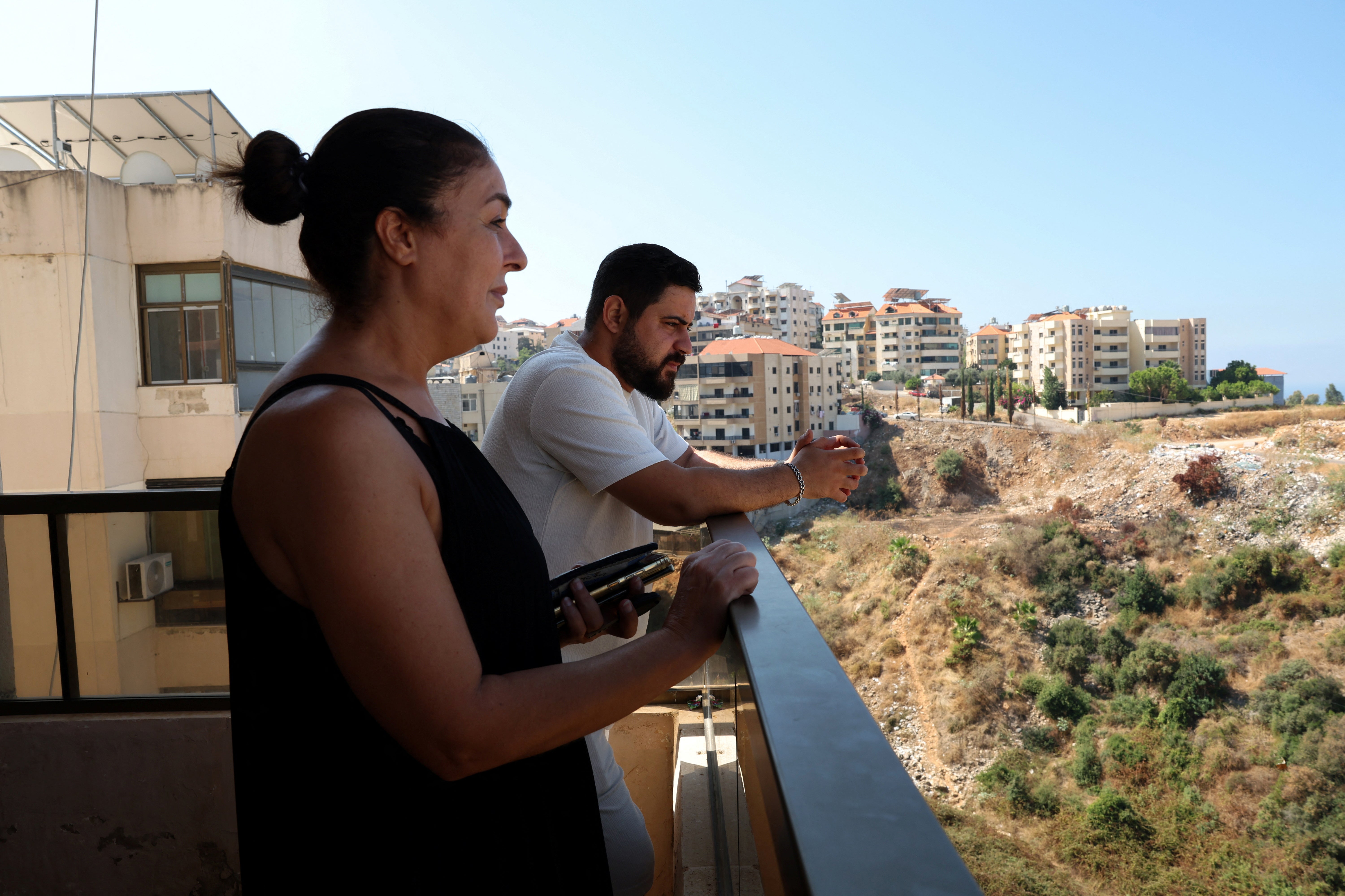 Ghada Fawaz, a Lebanese woman who is hosting displaced people who fled from southern Lebanon stands next to one of the displaced residing in the building in Aramoun, Lebanon