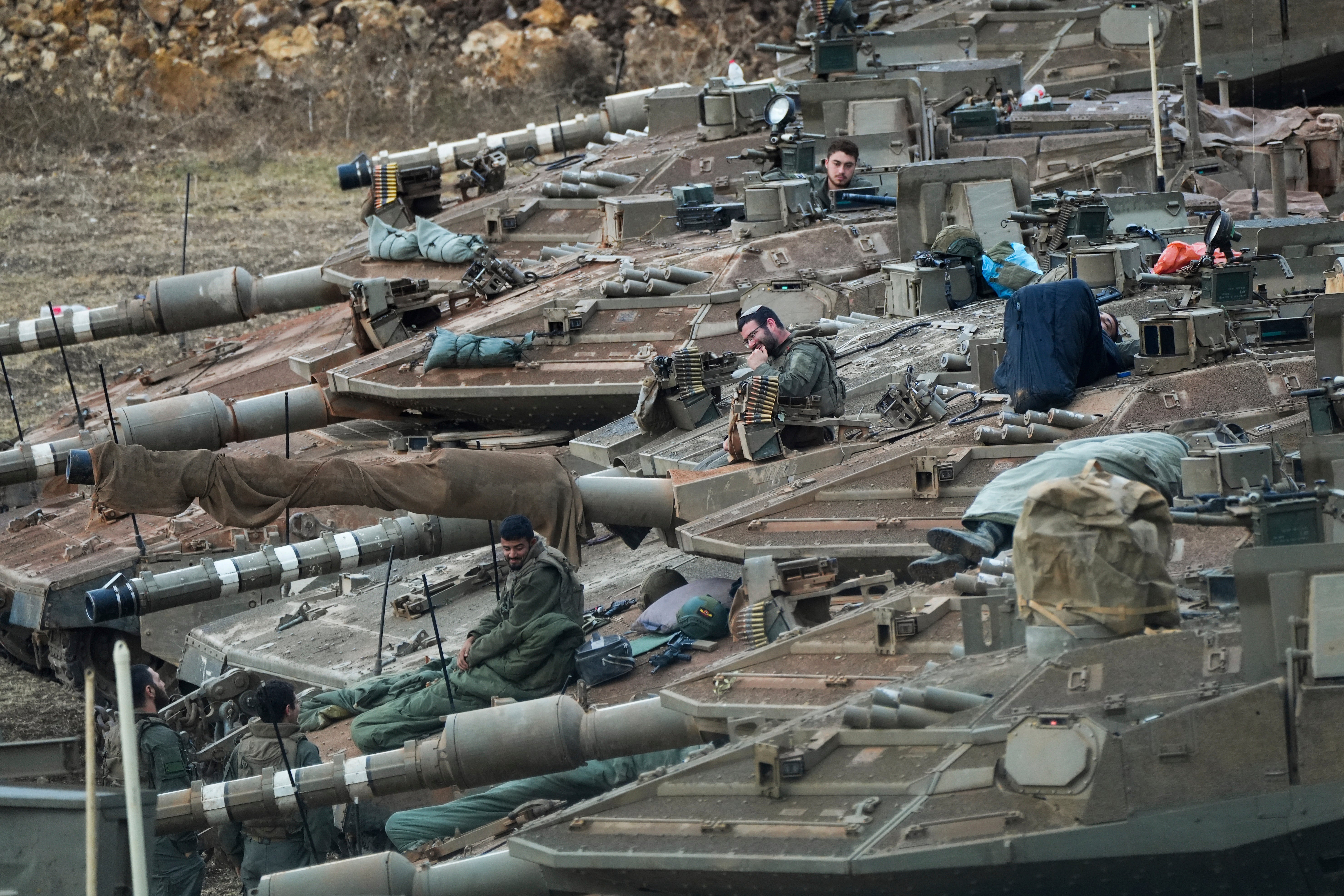 Israeli soldiers work on tanks in a staging area in northern Israel near the Israel-Lebanon border, Tuesday, 1 October 2024