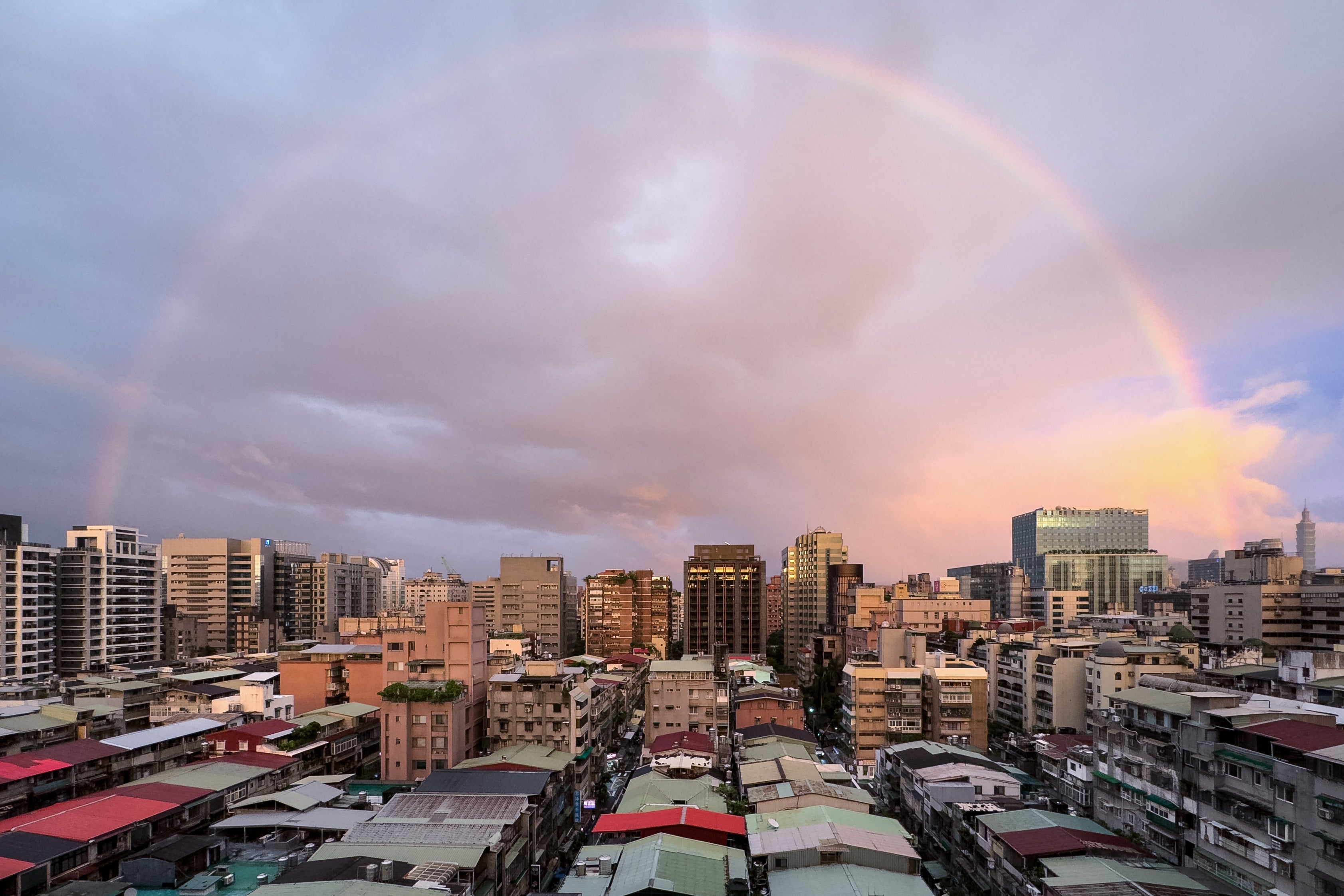 A rainbow can be seen over the city of Taipei at sunset