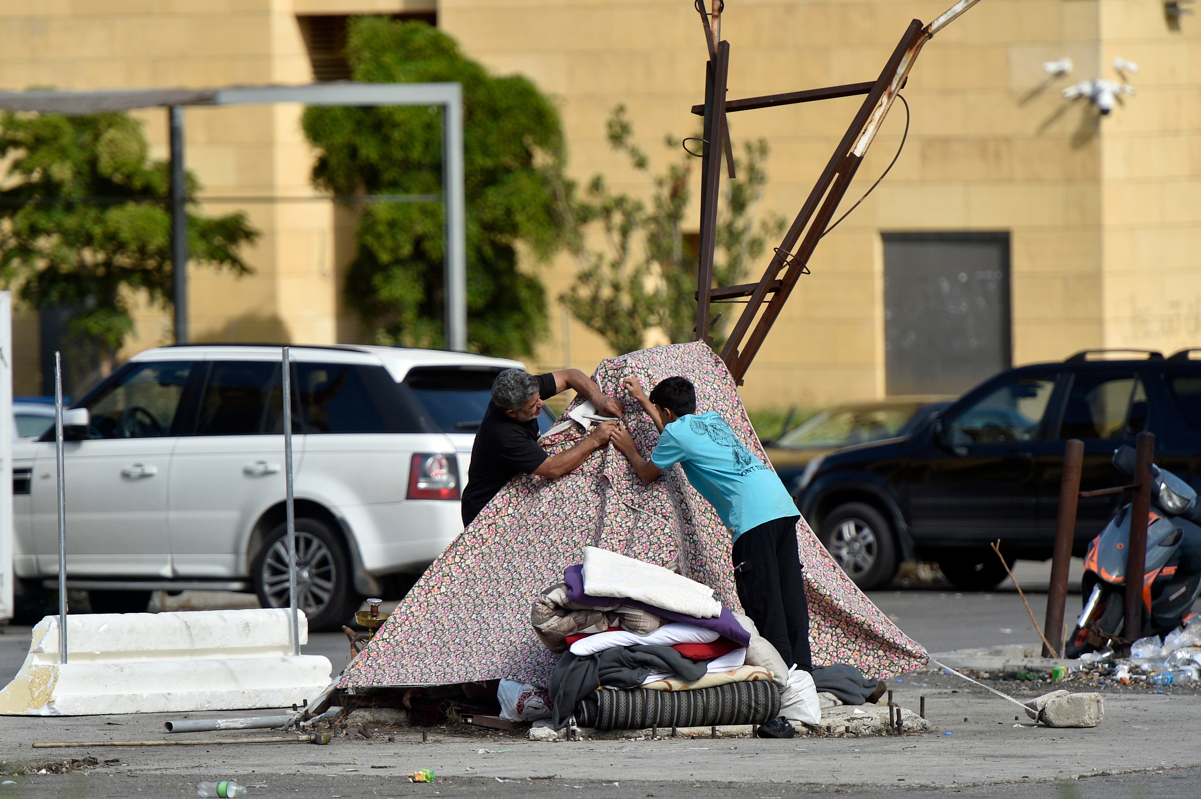 People displaced amid Israeli military strikes in Lebanon prepare a makeshift tent in Beirut