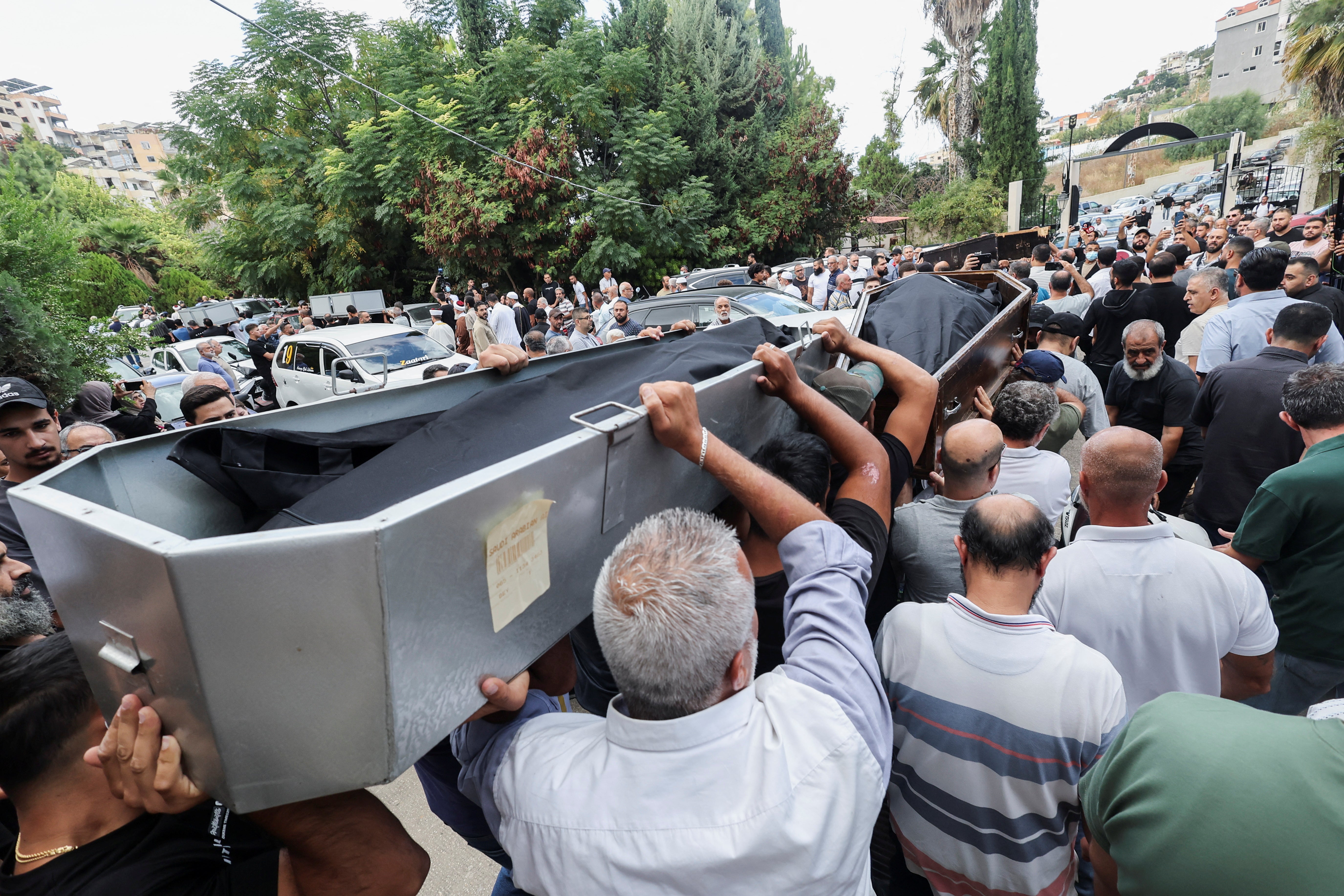 Mourners carry bodies during the collective funeral held for people killed in an Israeli attack on Sunday in the city of Ain Deleb in southern Lebanon