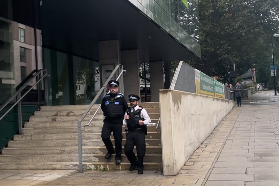 Police on footpatrol walk by the main entrance of Westminster Academy