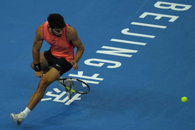 Carlos Alcaraz plays a shot between his legs (Ng Han Guan/AP)