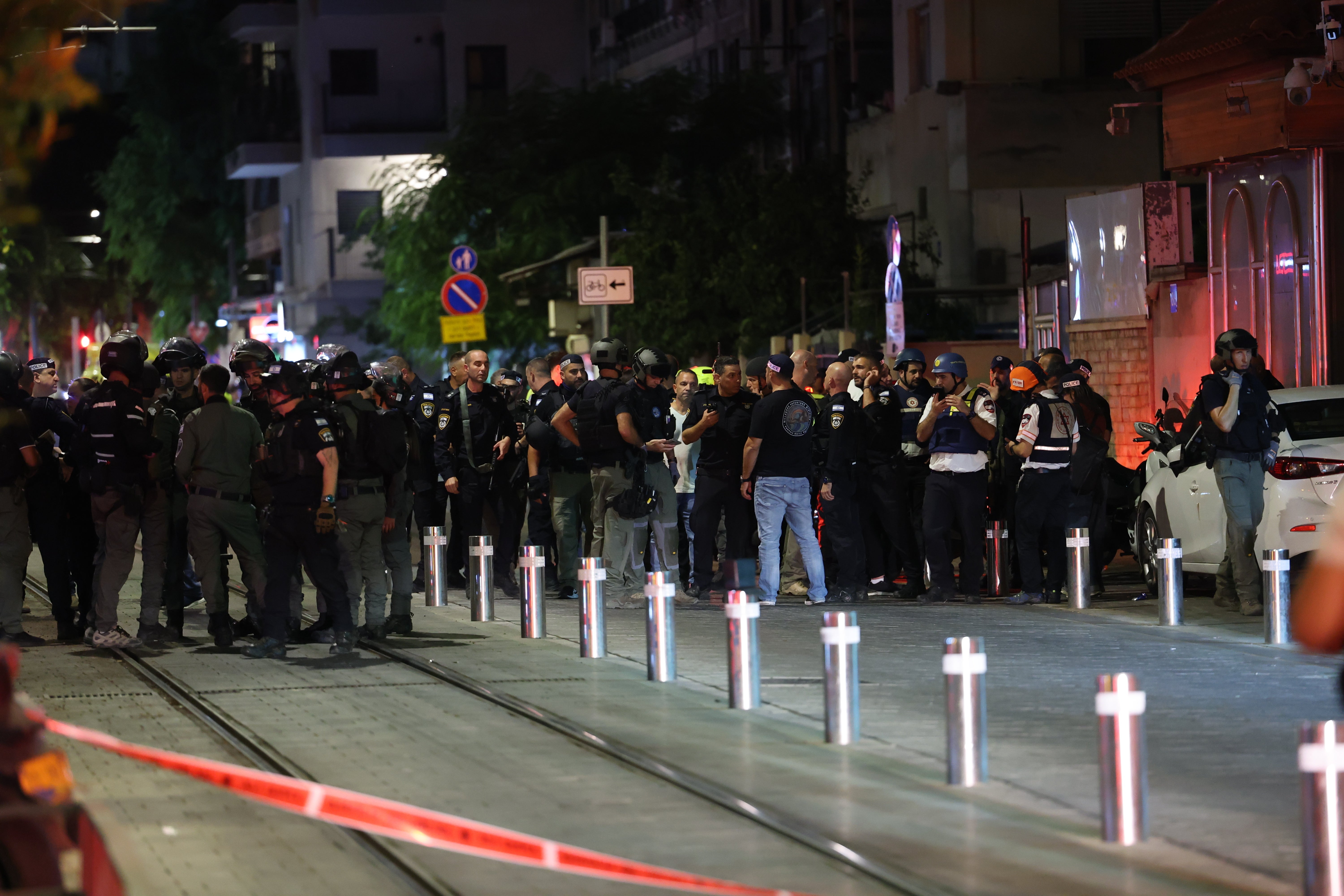 Israeli security and police officers inspect the site of a shooting incident in Tel Aviv, Israel, on Tuesday