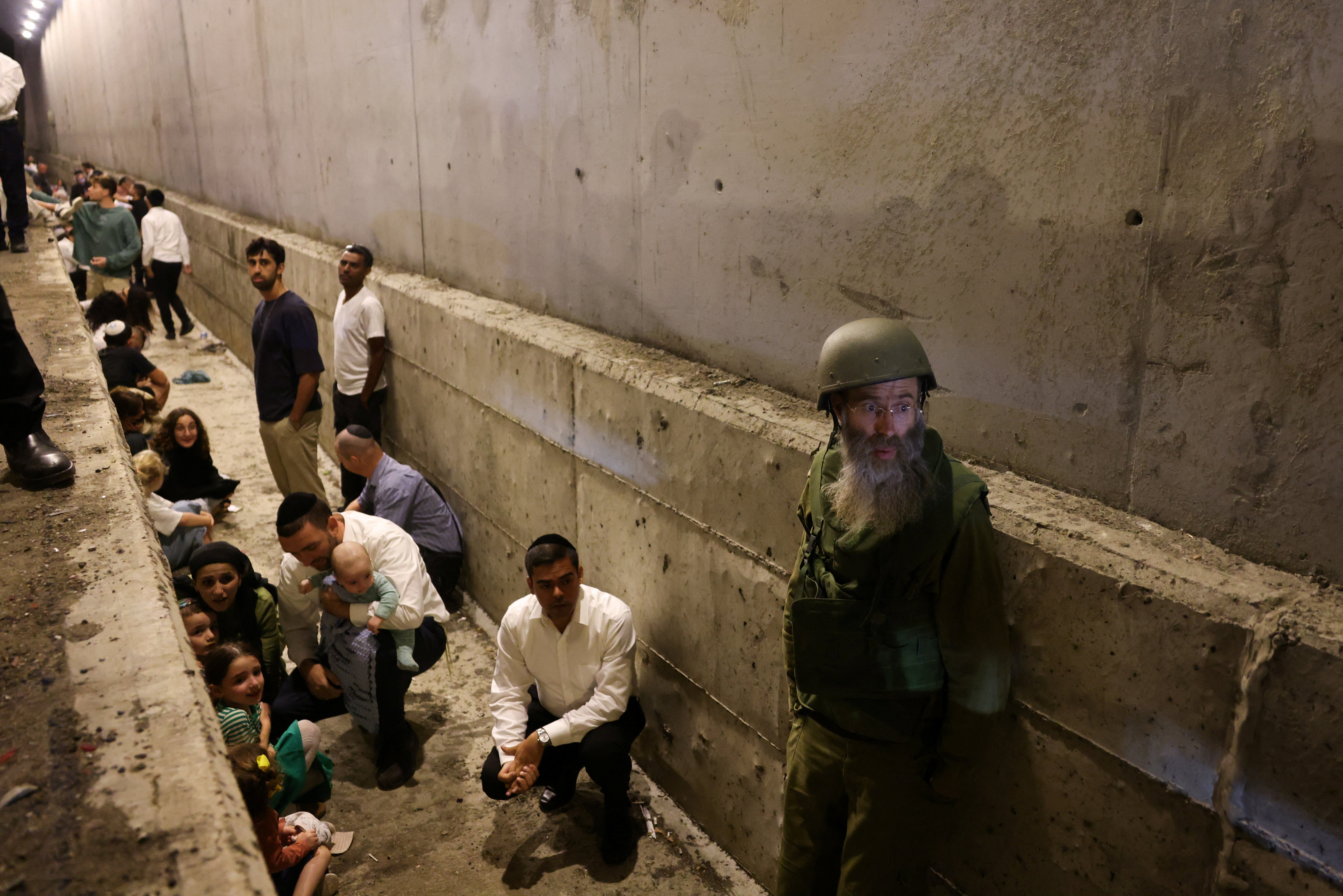 People take shelter during an air raid siren in central Israel