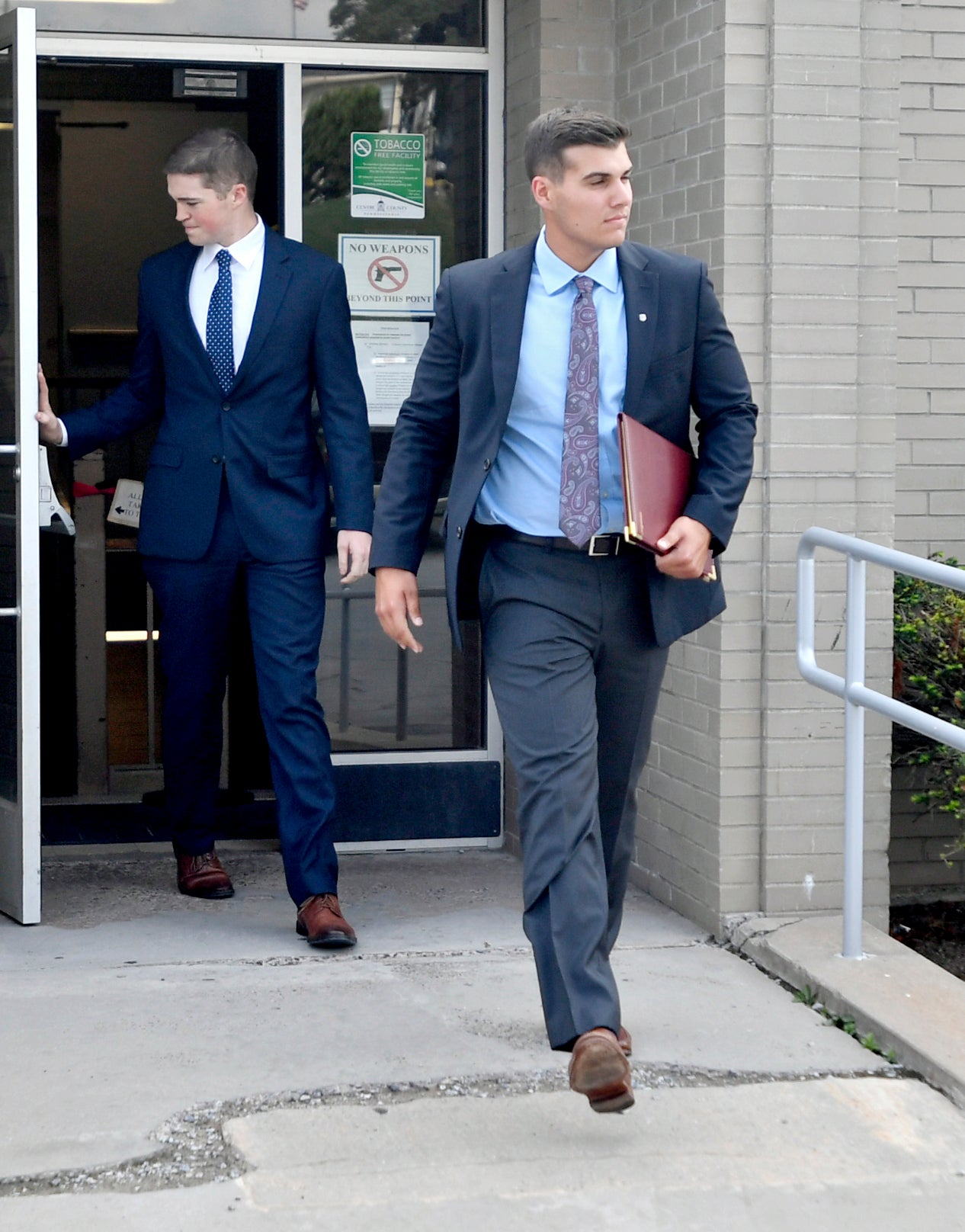 Beta Theta Pi member Daniel Casey, right, leaves the Centre County courthouse in Bellefonte, July 11