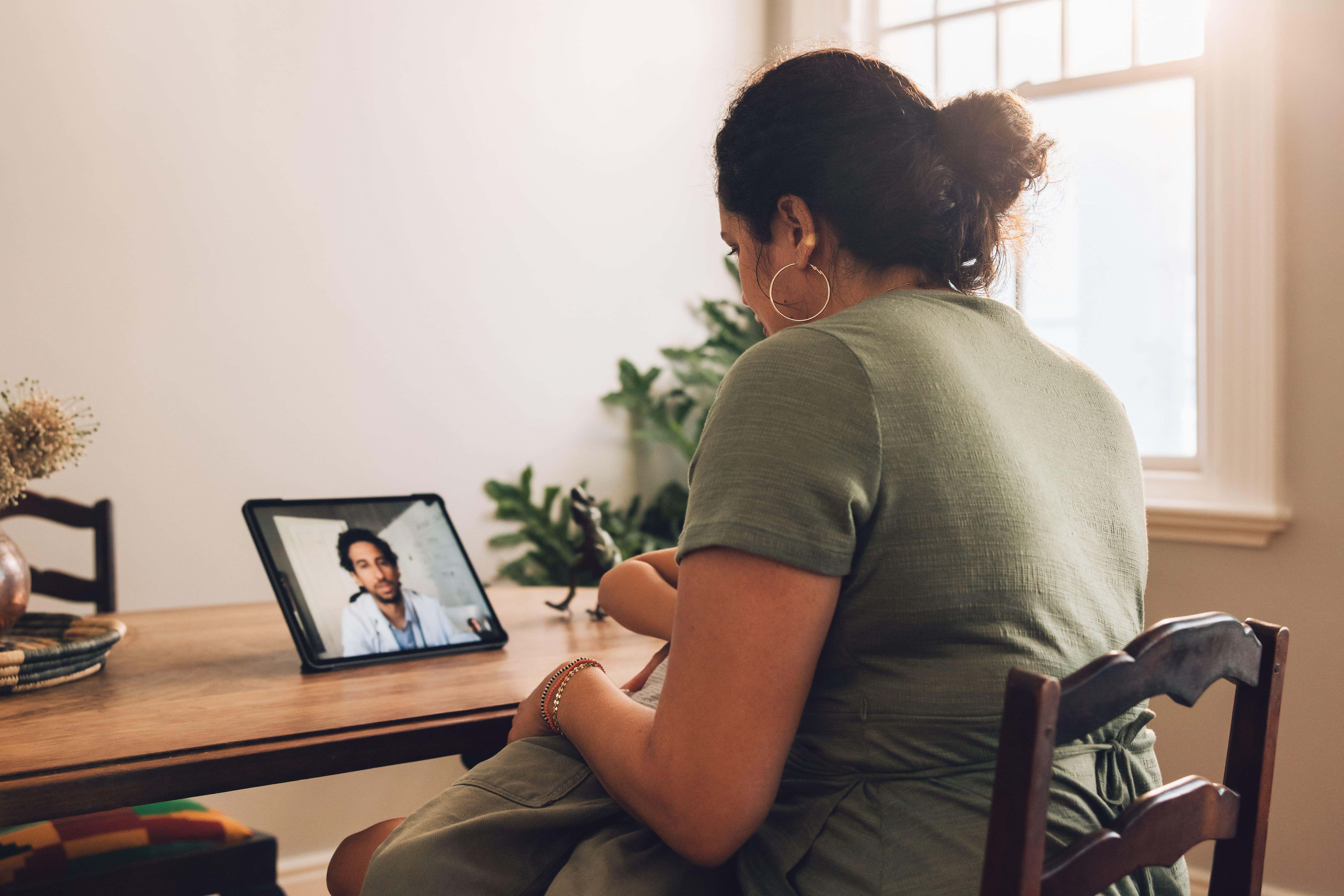 A mother and son having a video call appointment with a doctor from home (Alamy/PA)