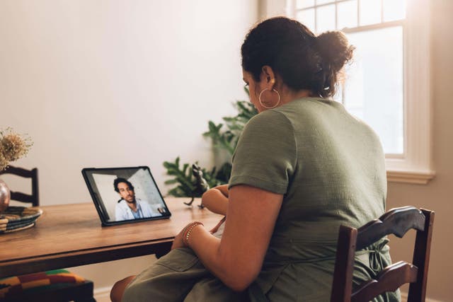 A mother and son having a video call appointment with a doctor from home (Alamy/PA)