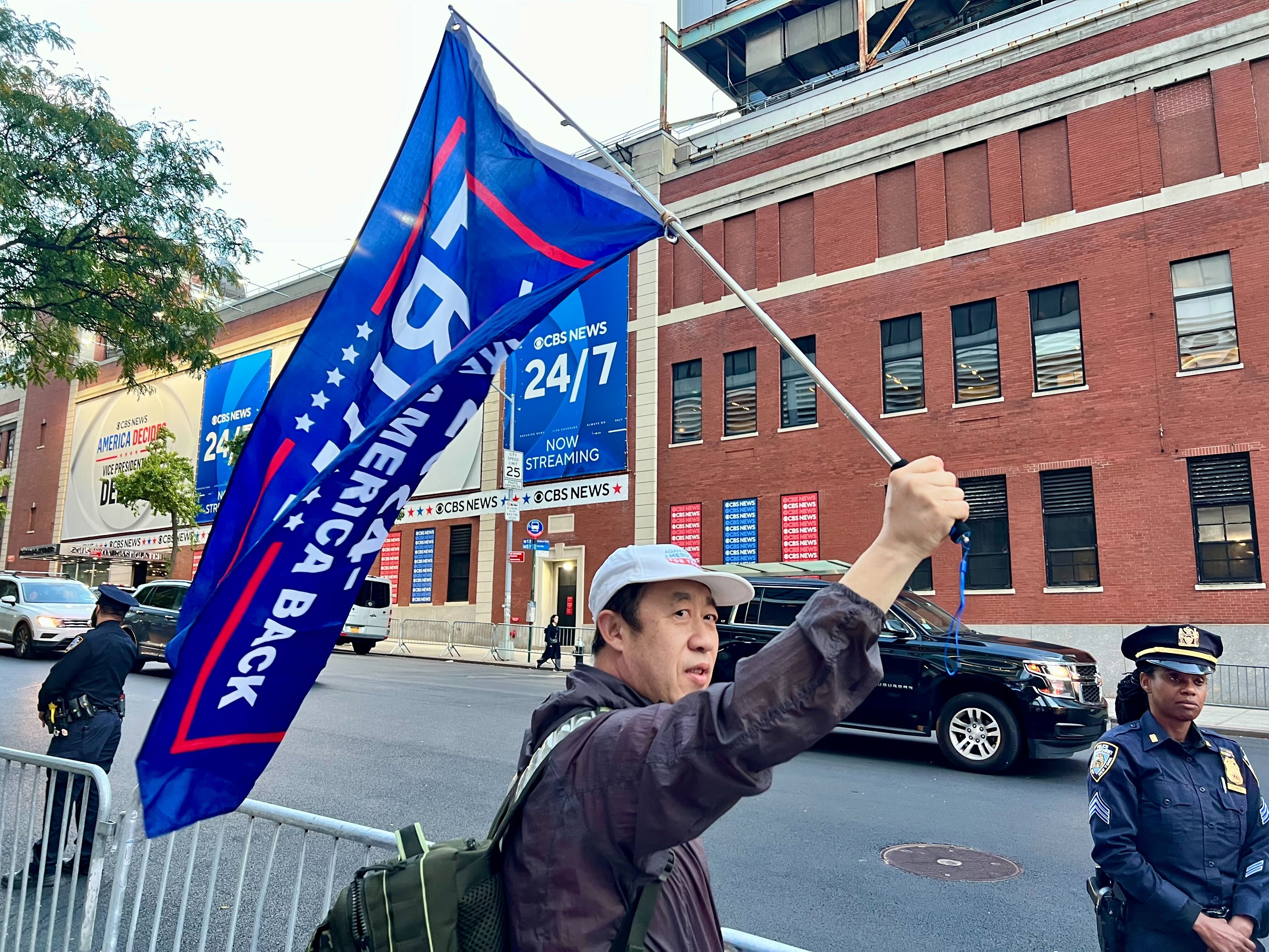 A Chinese Americans for Trump supporter cheers on JD Vance outside of the CBS Broadcast Center on October 1, 2024