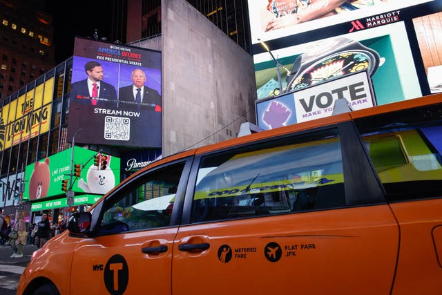 <p>A screen in New York’s Times Square shows the debate between JD Vance and Tim Walz </p>