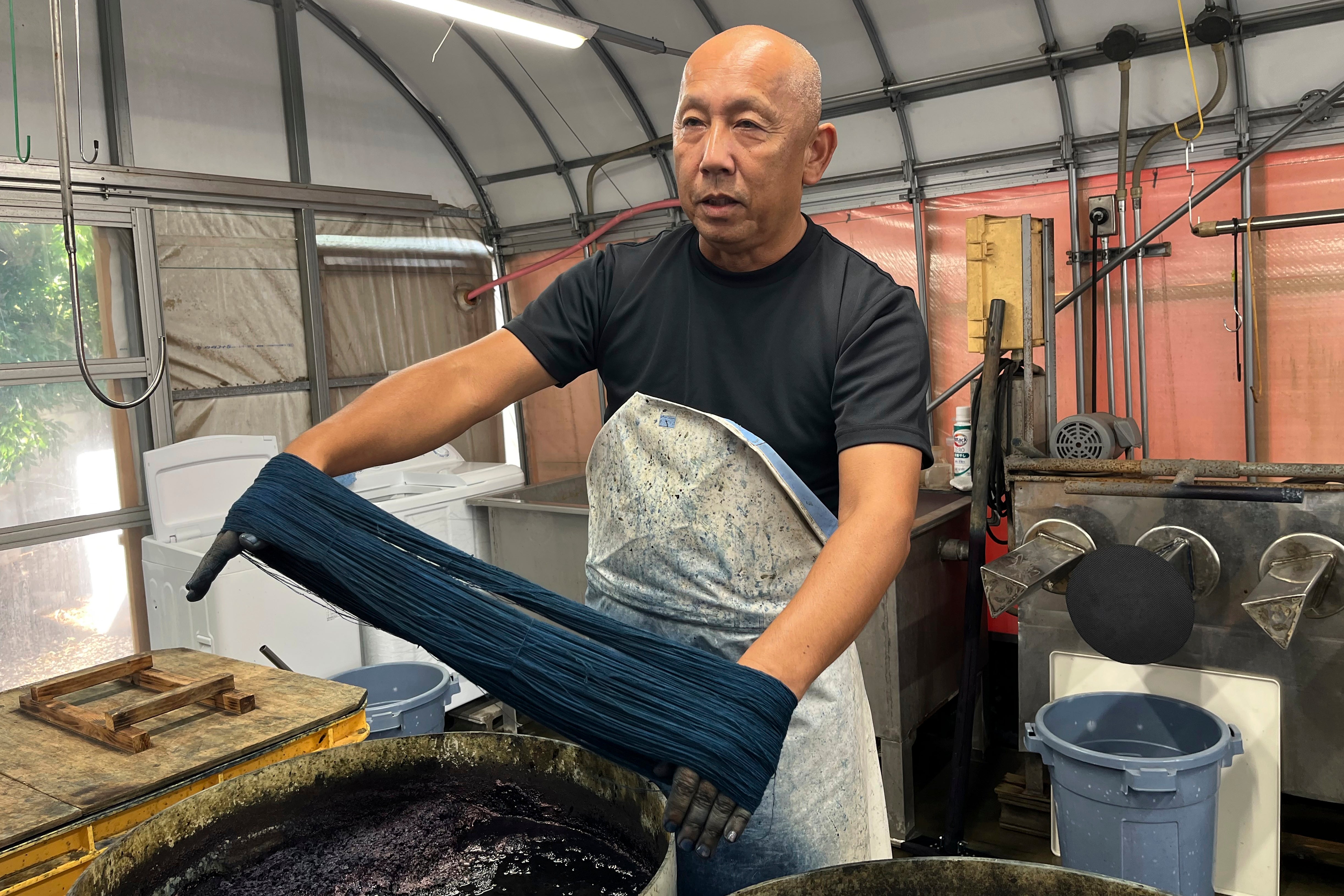 Dyeing craftsman Yoshiharu Okamoto shows how he dyes the threads in indigo for denim at Momotaro Jeans in Kojima, Okayama prefecture