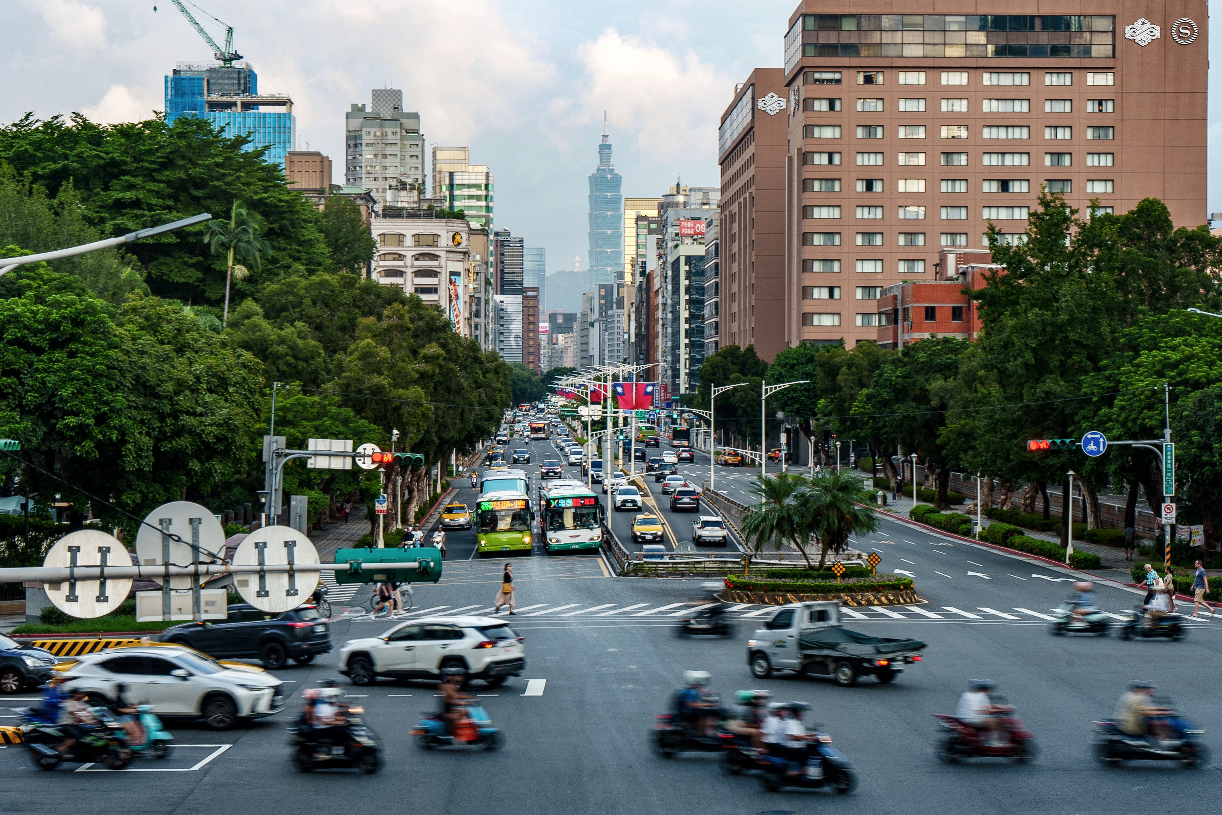 Commuters ride along a street decorated with Taiwan’s national flags in Taipei